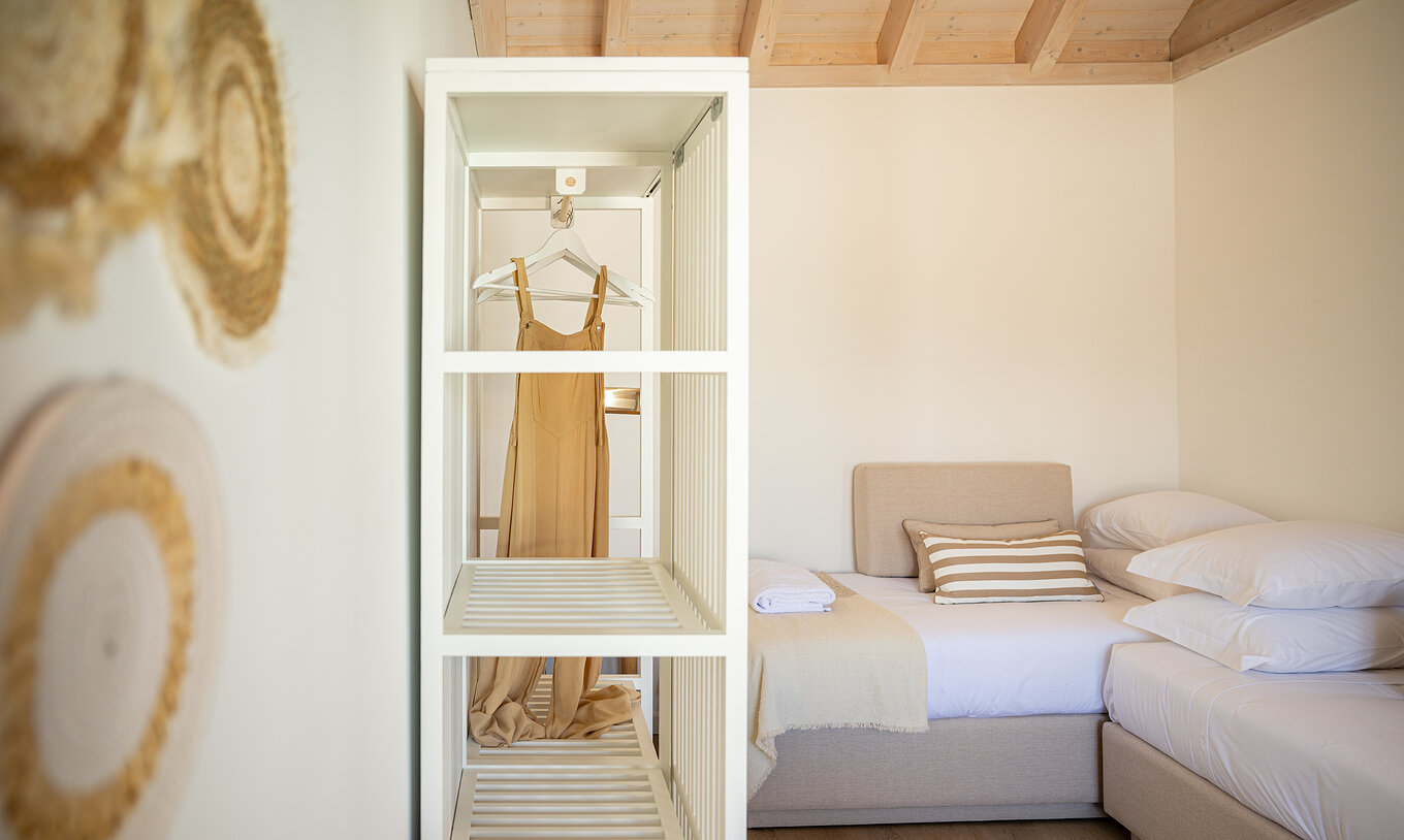 La Standard Villa de Pestana Comporta Village Residences tiene un vestidor con armario blanco y decoración de paja