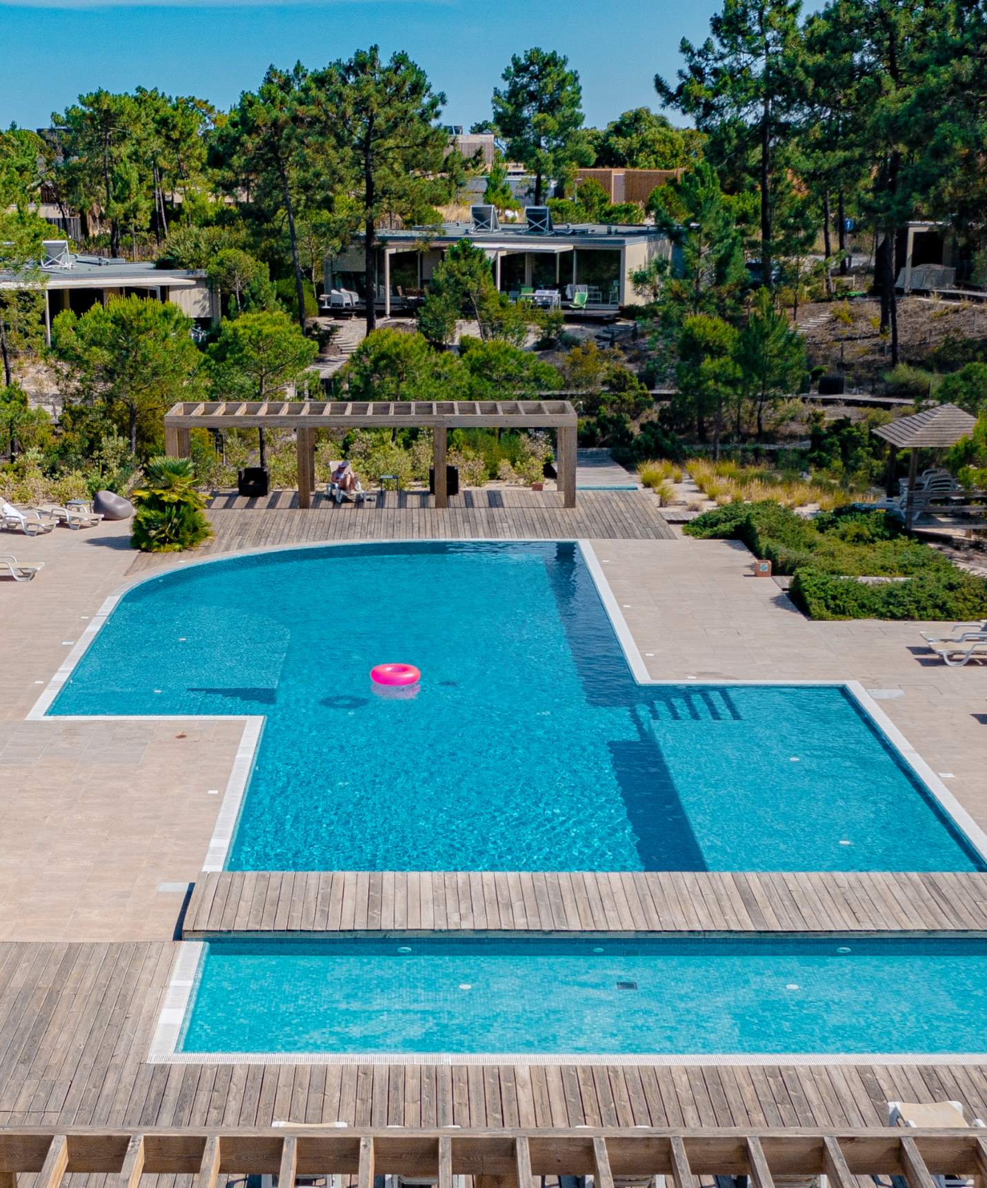 Piscina exterior del resort en Tróia, cerca de Comporta, con tumbonas alrededor y naturaleza a su alrededor