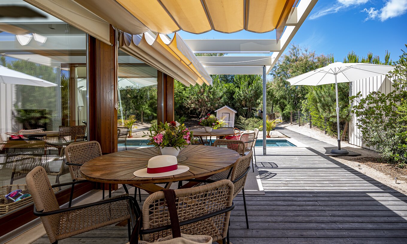 La Aqua Villa del Pestana Tróia Eco Resort tiene una terraza con mesas y sillas donde se puede descansar