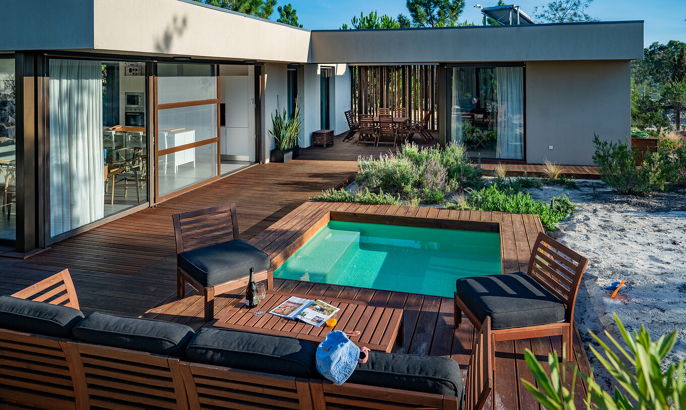 Las Beach Villas con Piscina Infantil del Pestana Tróia Eco Resort tienen sofás y sillas junto a la piscina infantil