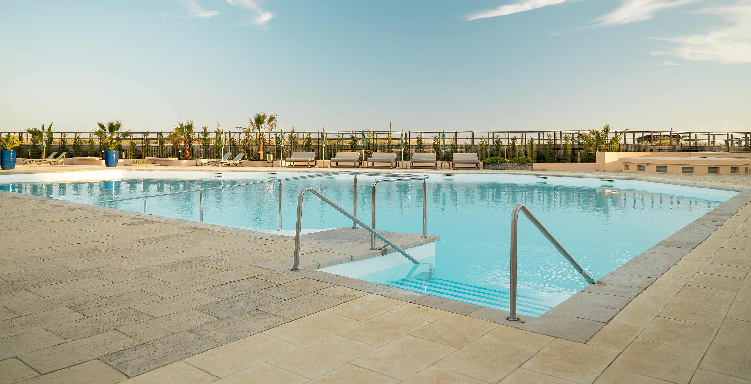 Piscina exterior del Pestana Alvor Beach Villas, tumbonas cómodas, palmeras, jardines y ambiente relajante