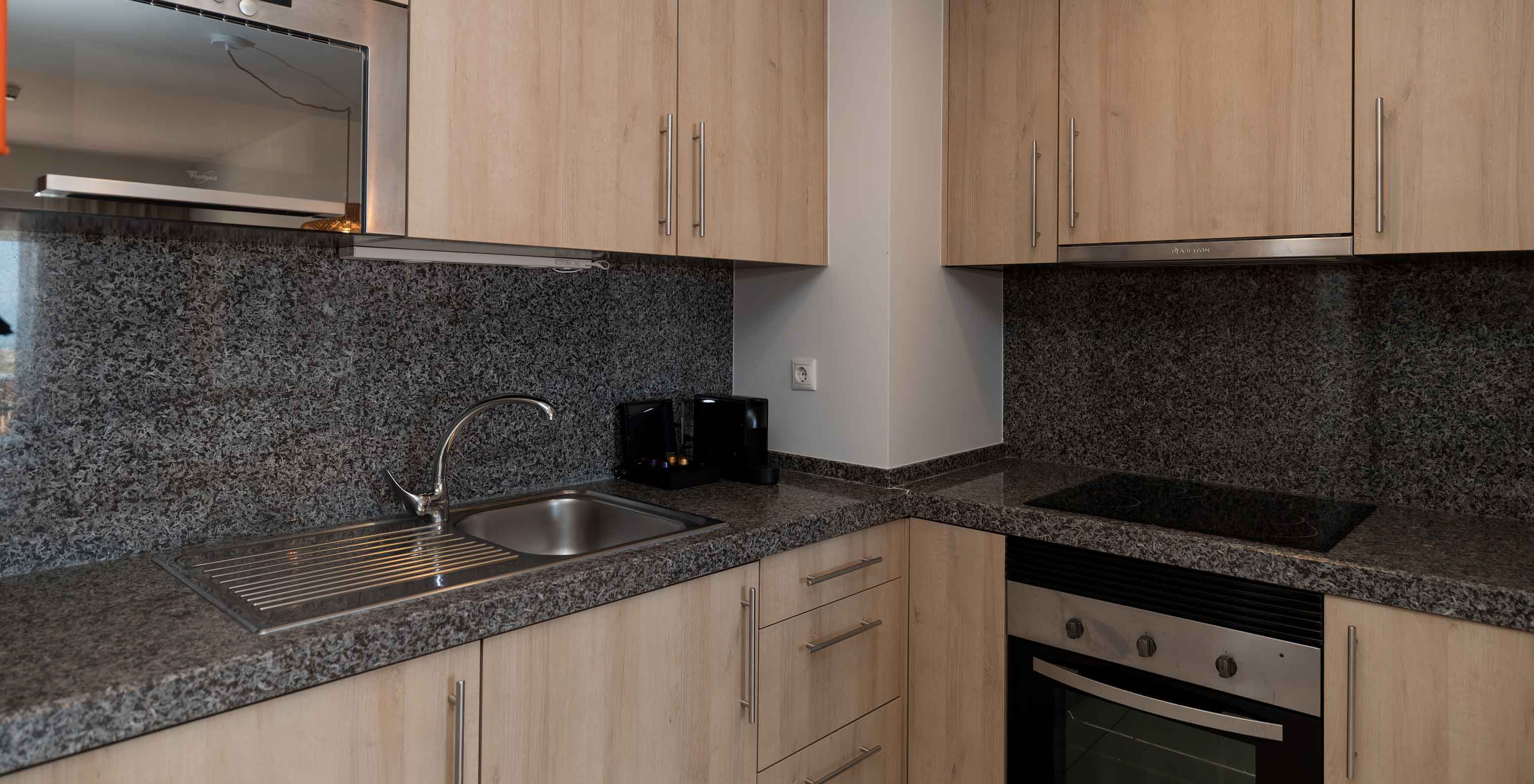 Apartamento T1 Vista Mar en Pestana Alvor Beach Villas tiene cocina equipada con fogón, microondas y armarios