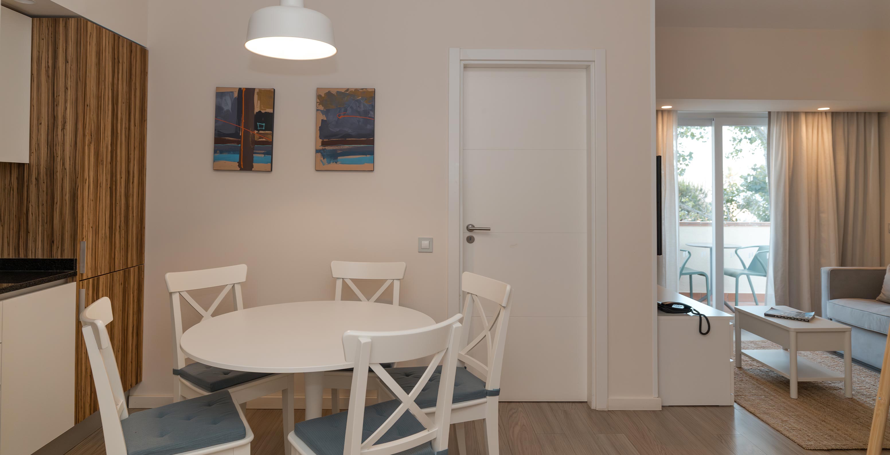 Villa 2 Habitaciones Vista Jardín en Pestana Alvor Beach Villas tiene sala con sofá, acceso al balcón y mesa de comedor