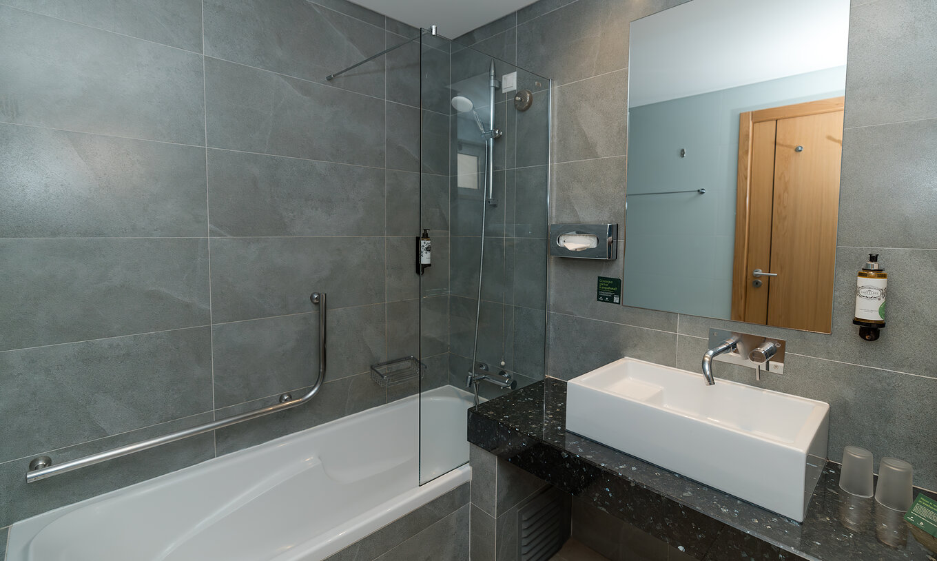 Apartamento T1 Vista Jardín en Pestana Alvor Beach Villas tiene un baño con bañera y lavabo con espejo