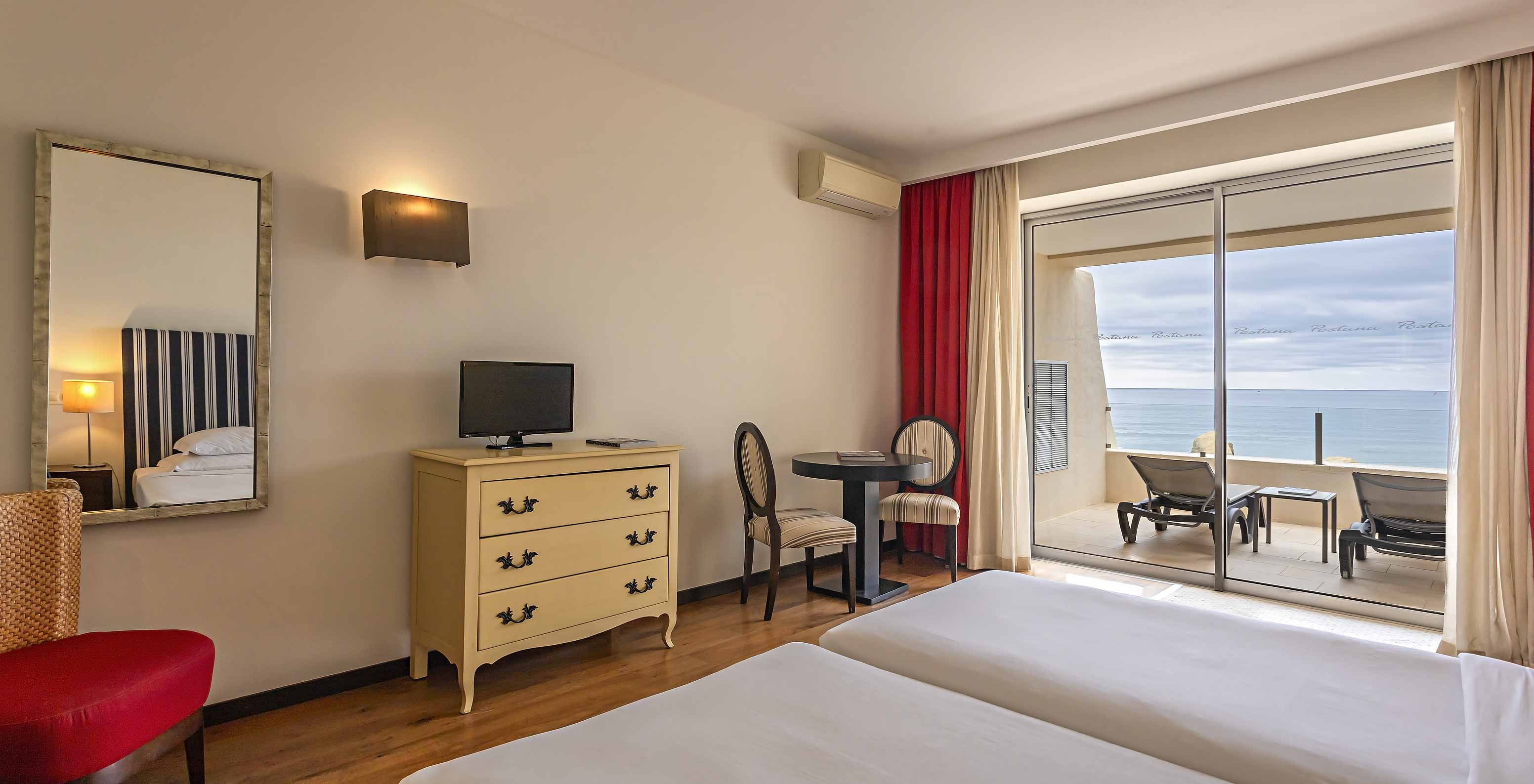 El Cliff Studio en Pestana Alvor Praia tiene un dormitorio doble con una cómoda, una televisión y un balcón con vistas al mar