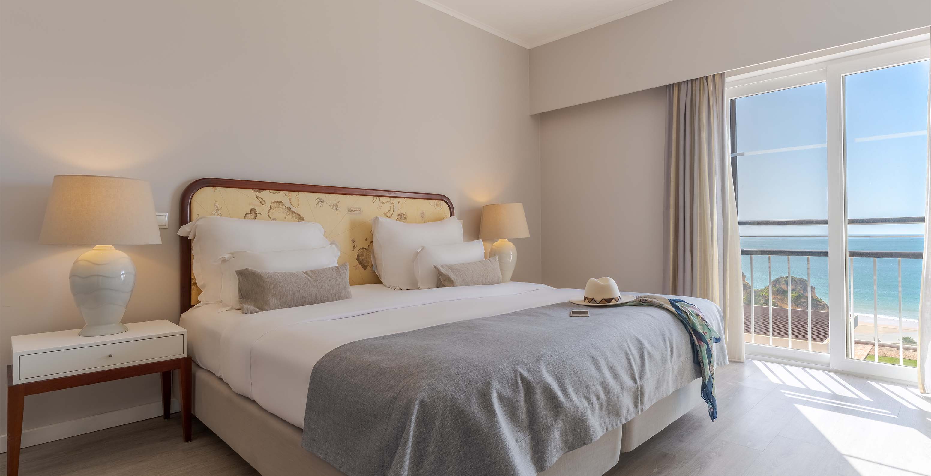 La Suite Luxo Vista Mar del Pestana Alvor Praia tiene cama matrimonial, mesa de noche con lámpara y ventanas con vista mar