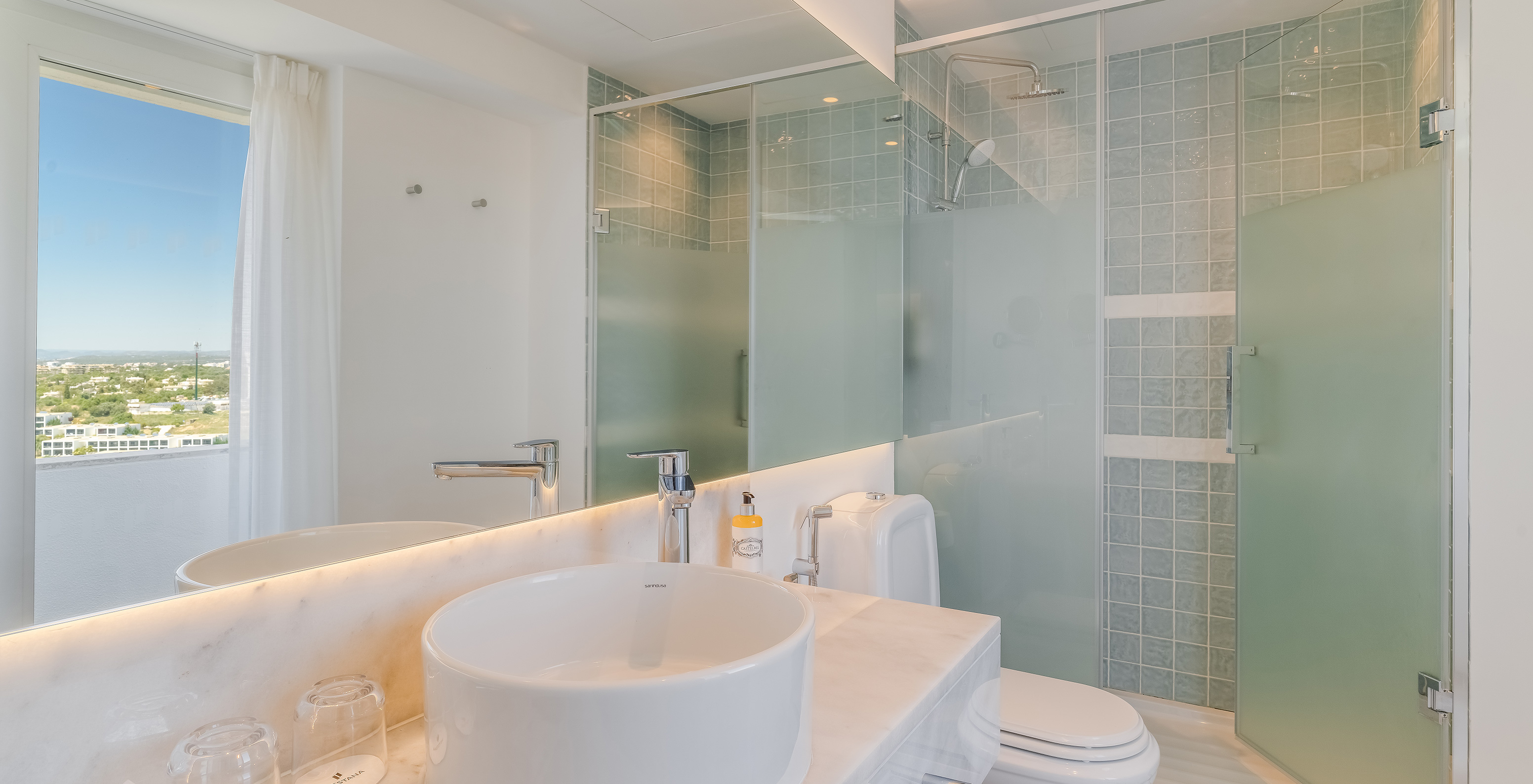El Cuarto Clásico Vista Jardín del Pestana Blue Alvor Beach tiene baño con lavabo y espejo, inodoro y ducha