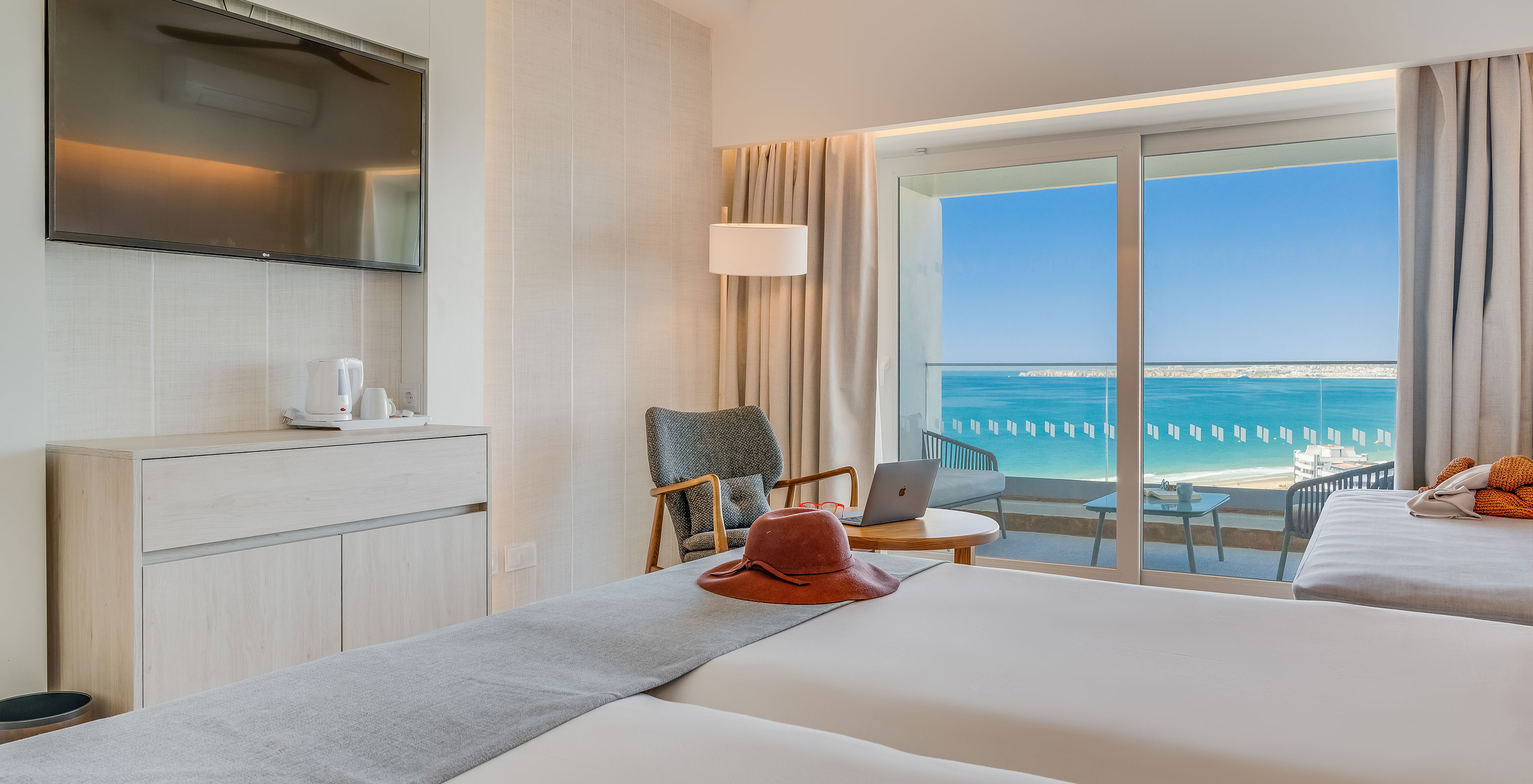 El Cuarto Familiar del Pestana Blue Alvor Beach tiene dos camas con sábanas blancas y televisión al fondo de la cama