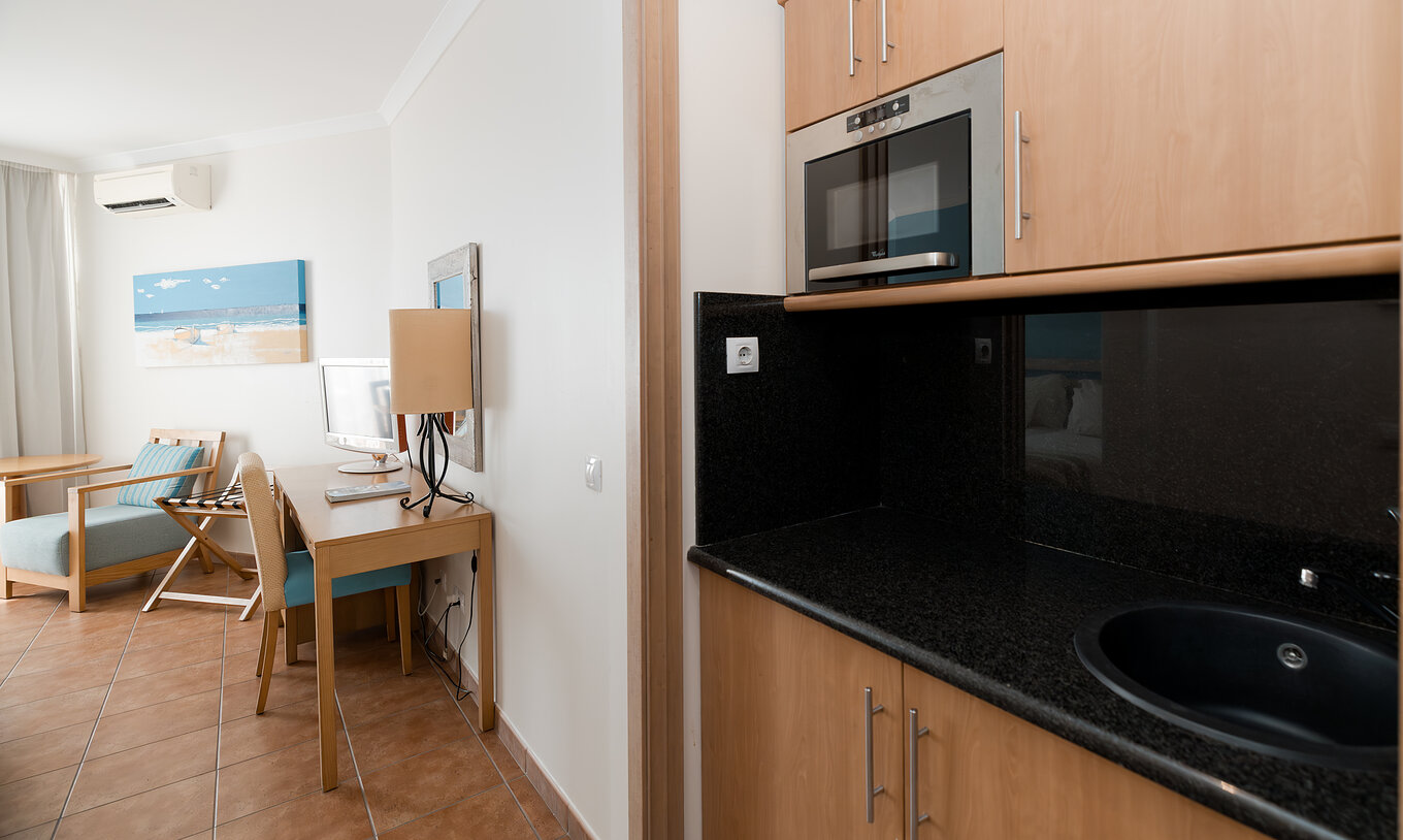 El Deluxe Vista Mar del Pestana Viking tiene escritorio y cocina pequeña con microondas y armarios