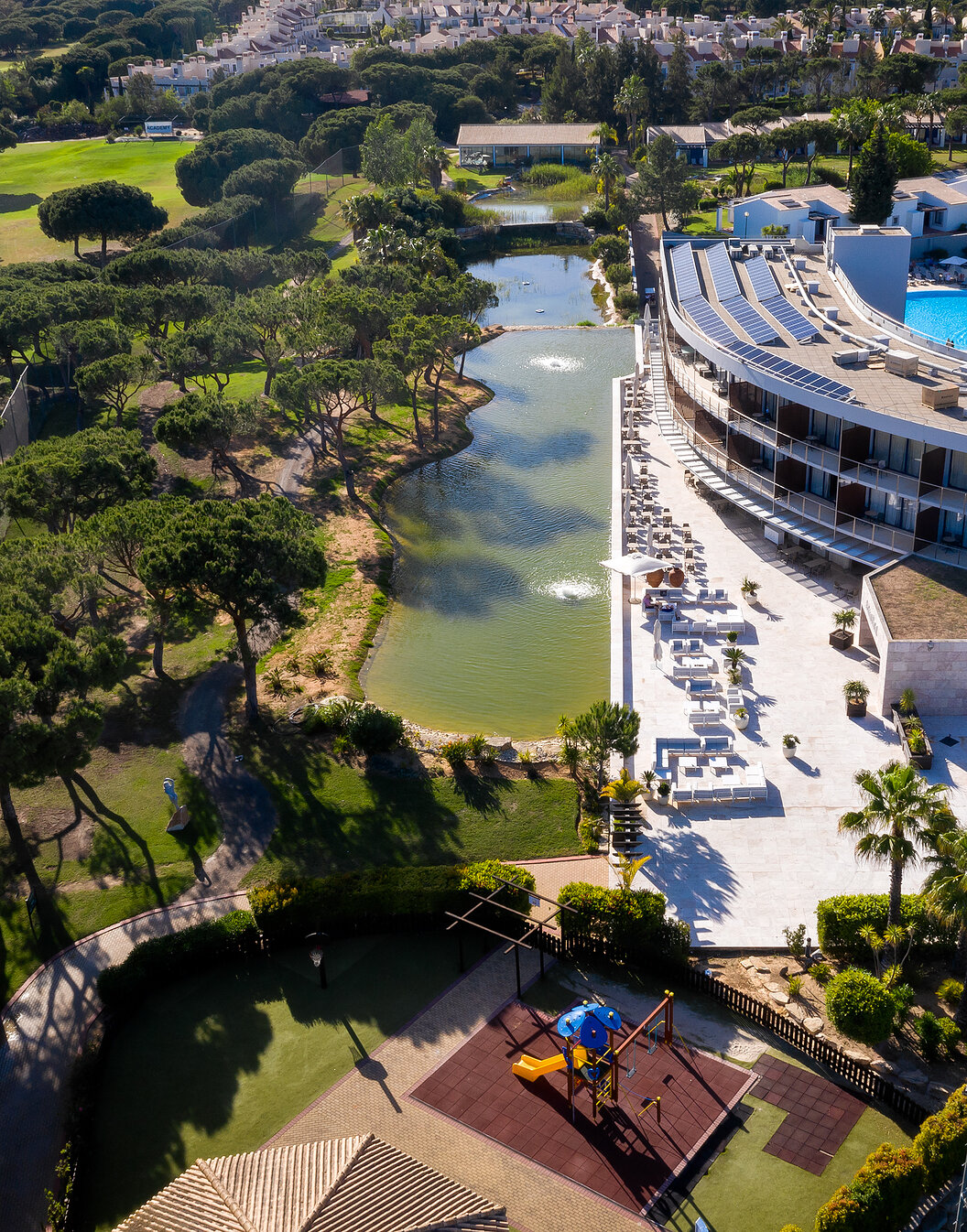 Vista de Pestana Vila Sol - Vilamoura, un hotel de 5 estrellas en Vilamoura con piscina, rodeado de un lago y vegetación