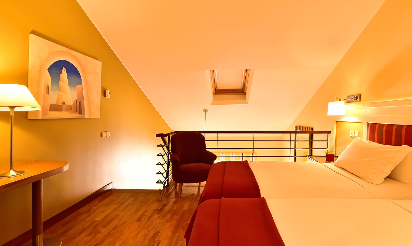 La Suite Mezzanine Familiar del Pestana Sintra Golf tiene una mezzanine con dos camas, una silla, cuadro y mesa