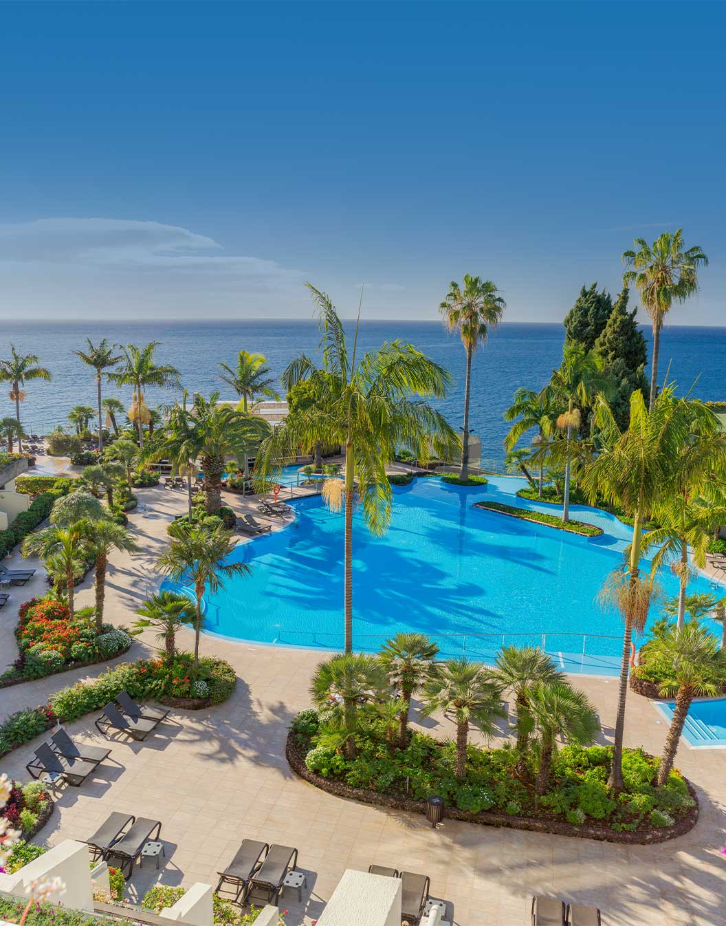 Vista exterior de la piscina y edificio de Pestana Carlton, un hotel en el centro de Funchal frente al mar