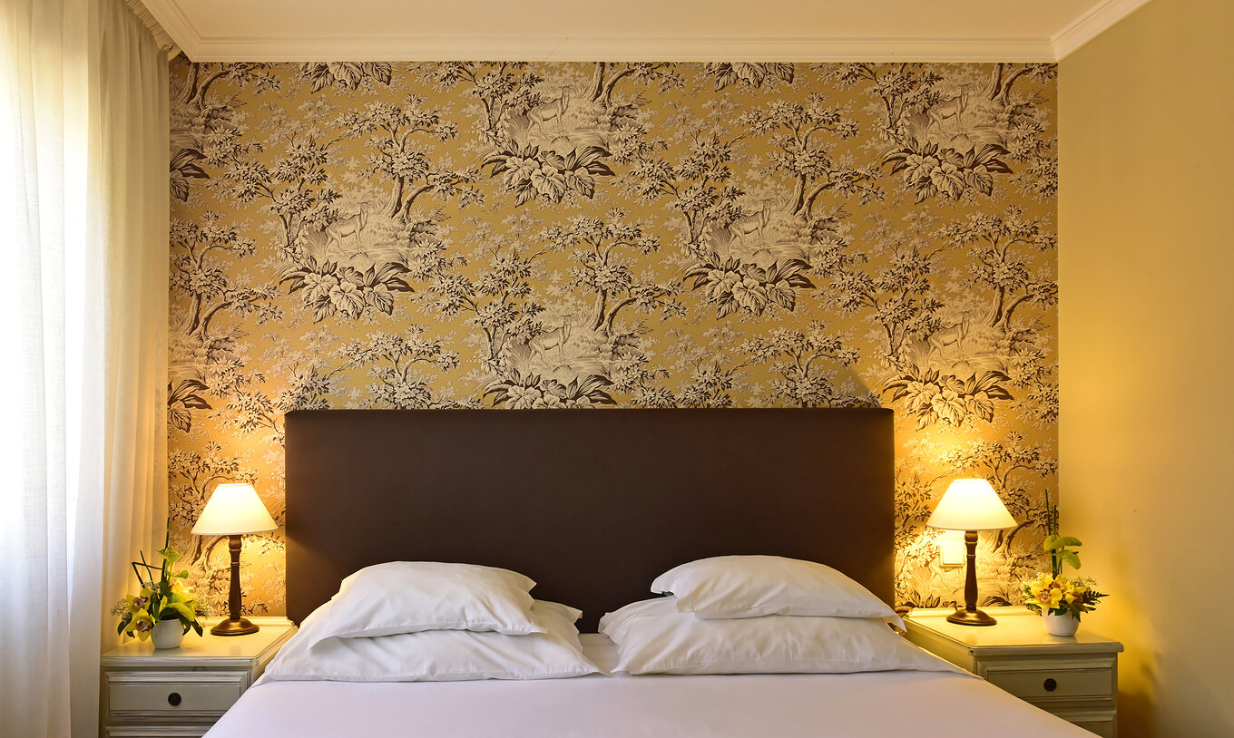 El Twin superior con Jacuzzi del Pestana Village tiene una cama de casal con cabecero y colcha marrón, y papel tapiz