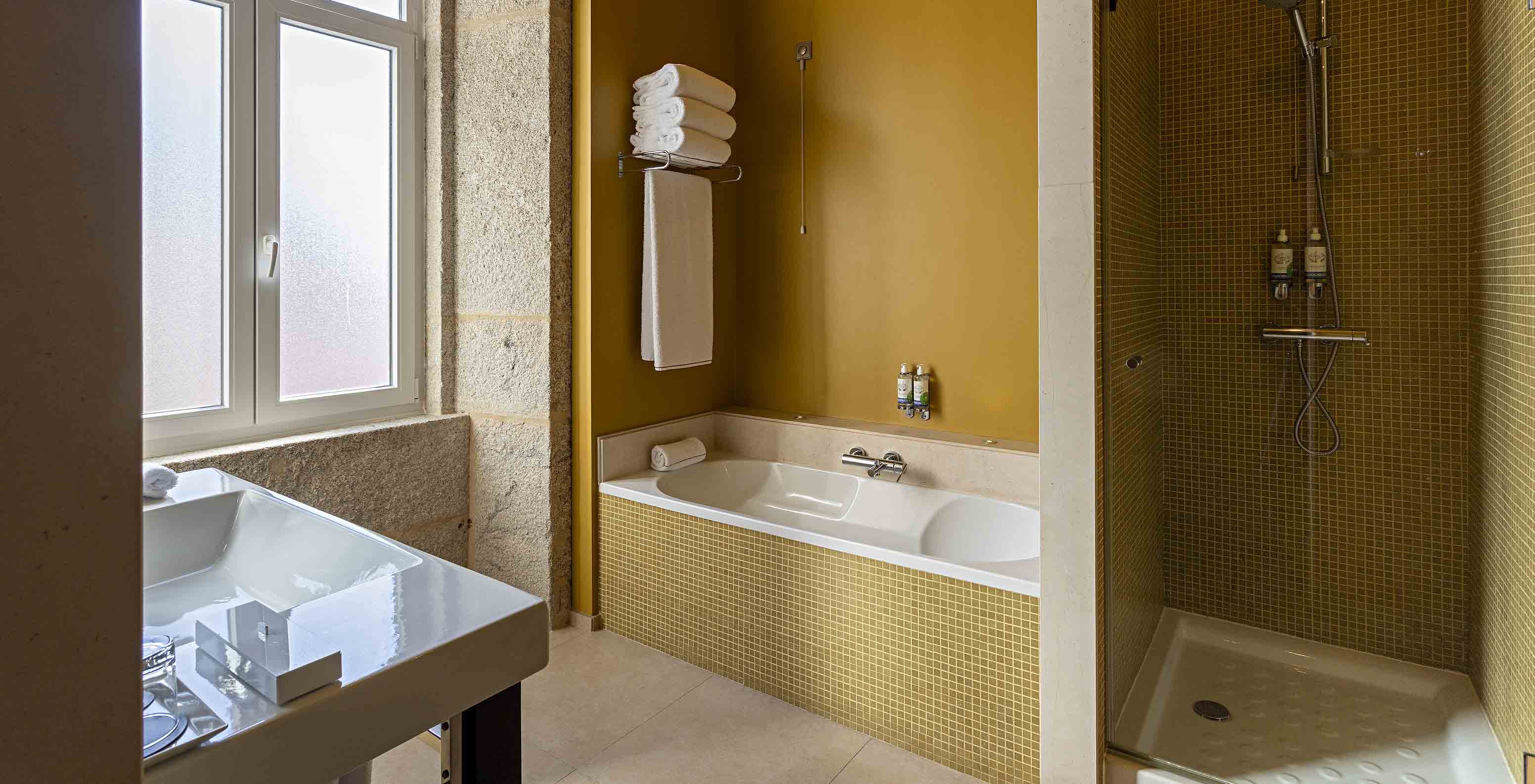 La Suite Nasoni tiene un baño con azulejos amarillos, bañera y zona de ducha