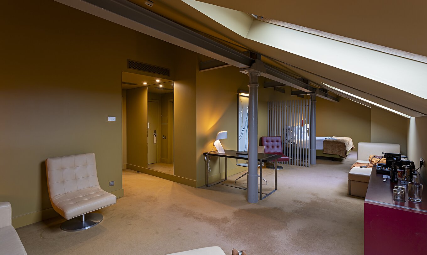 El Loft Ático del Pestana Palácio do Freixo tiene sofá beige de piel, escritorio y mueble rojo