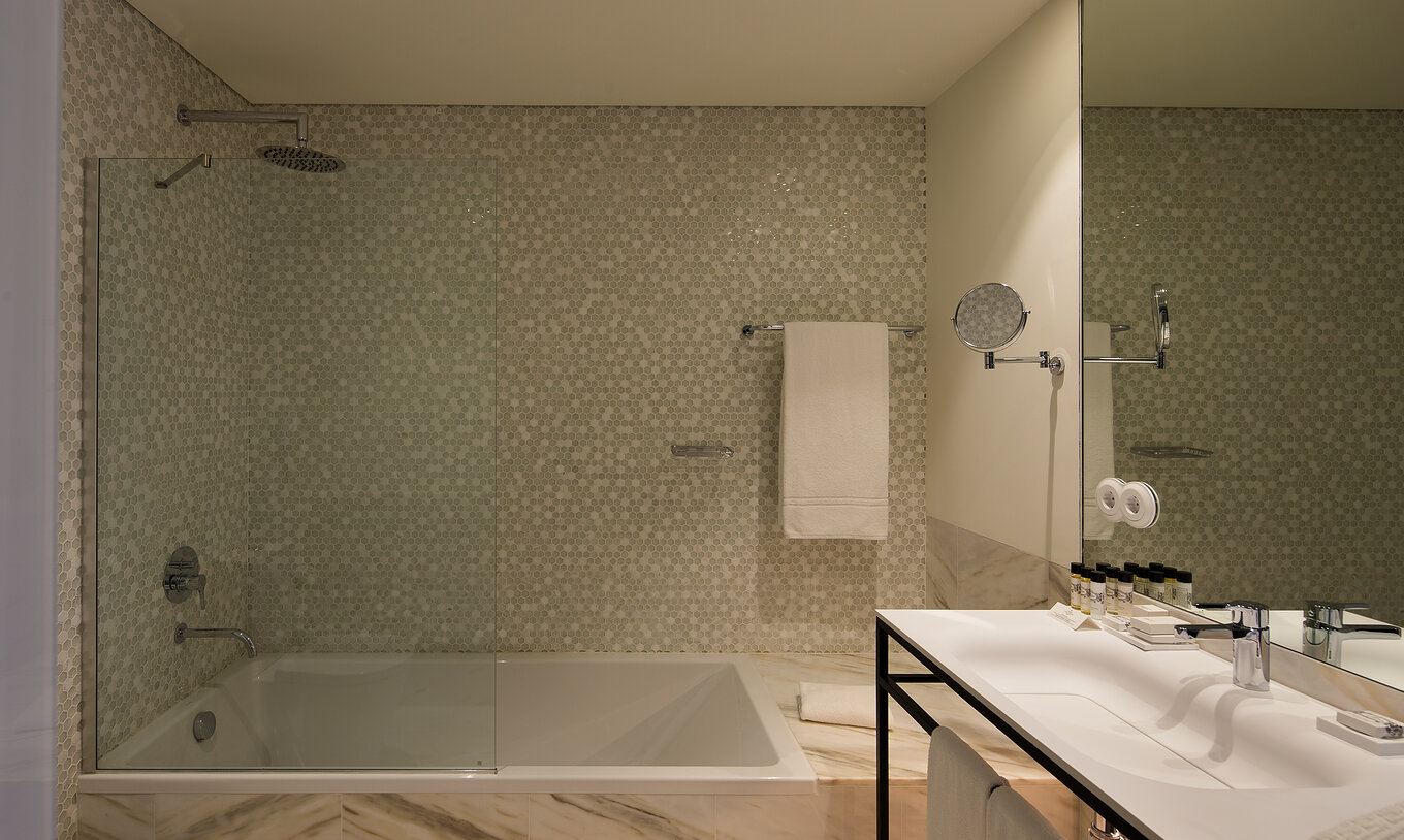 El Deluxe Executive Grand View del Pestana Porto - A Brasileira tiene una bañera grande con ducha con azulejos hexagonales
