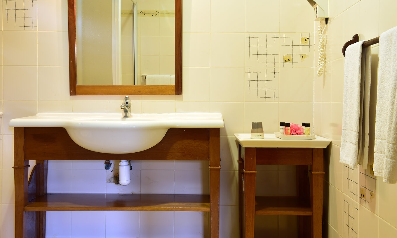 La Standard Suite del Pestana Equador Ilheu das Rolas tiene un baño con una mesa y un lavabo con espejo