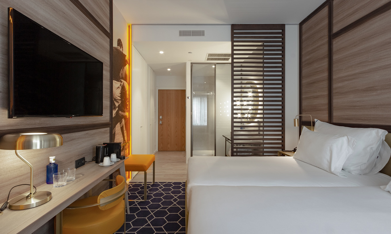 El Premium con Vista del Pestana CR7 Gran Vía Madrid tiene dos camas juntas y divisoria de madera para el baño