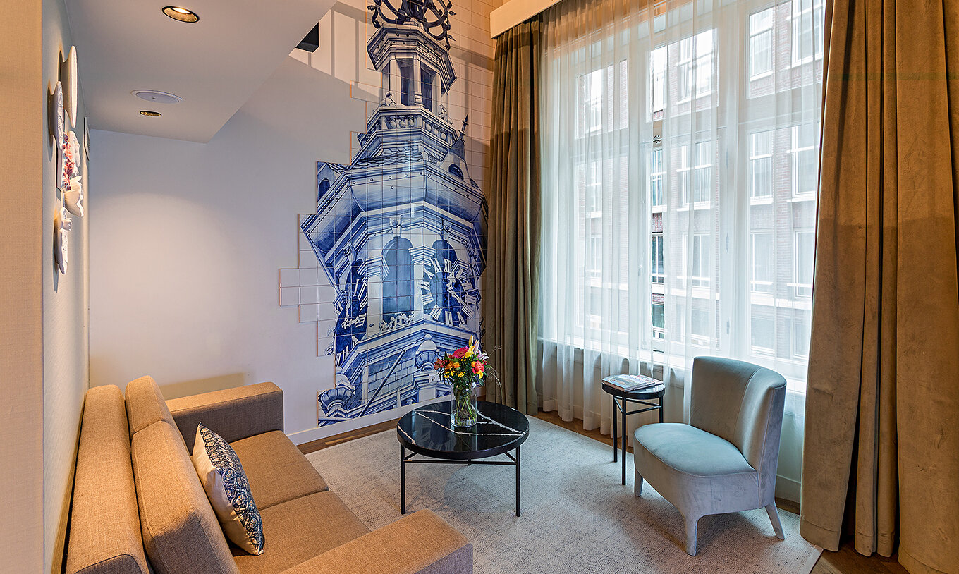 La Suite Mezzanine del Pestana Amsterdam Riverside tiene sala de estar con sofá, mesa de centro con flores y azulejos