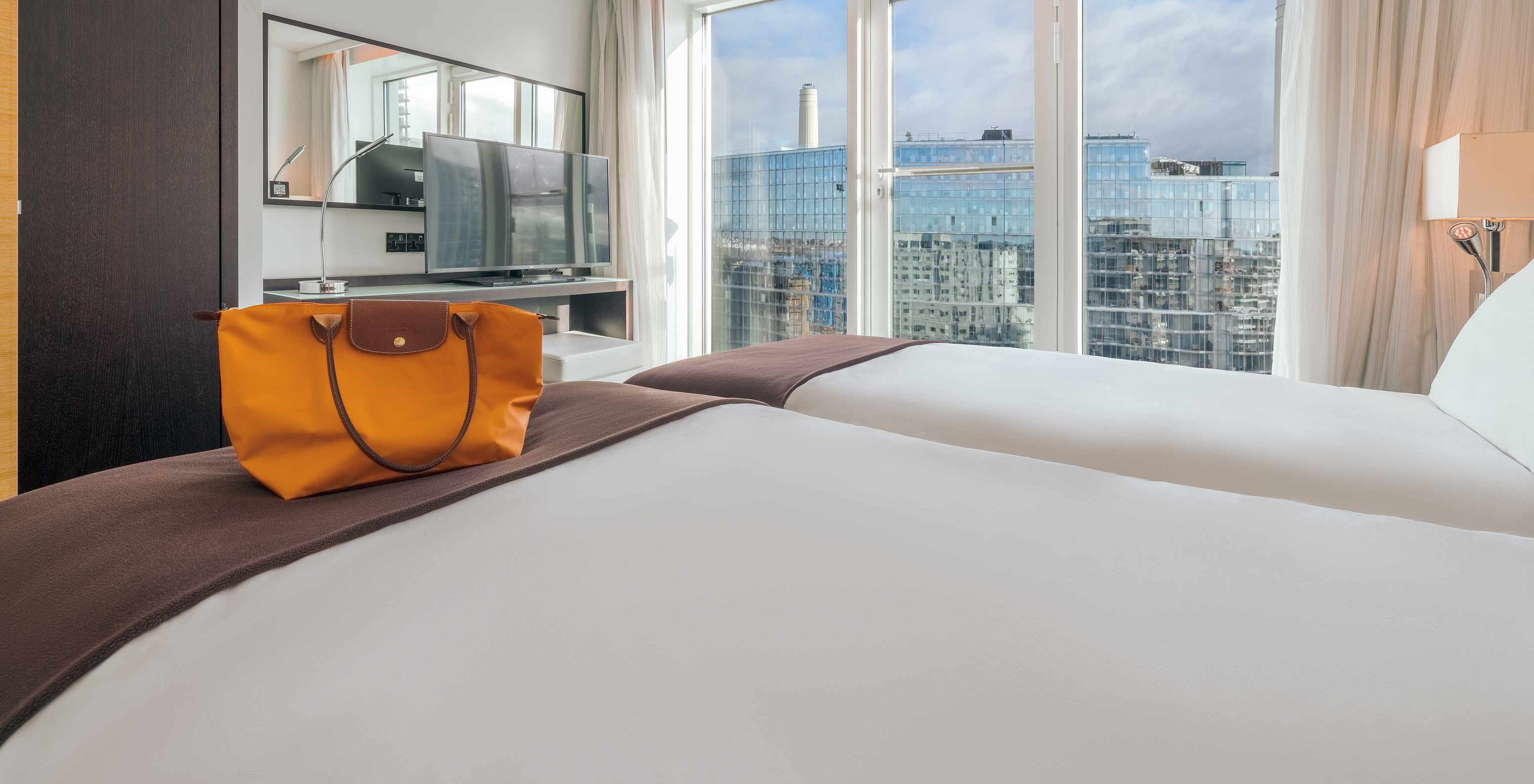 El Superior Twin del Pestana Chelsea Bridge tiene dos camas, TV, espejo, ventana con vista ciudad y cortinas