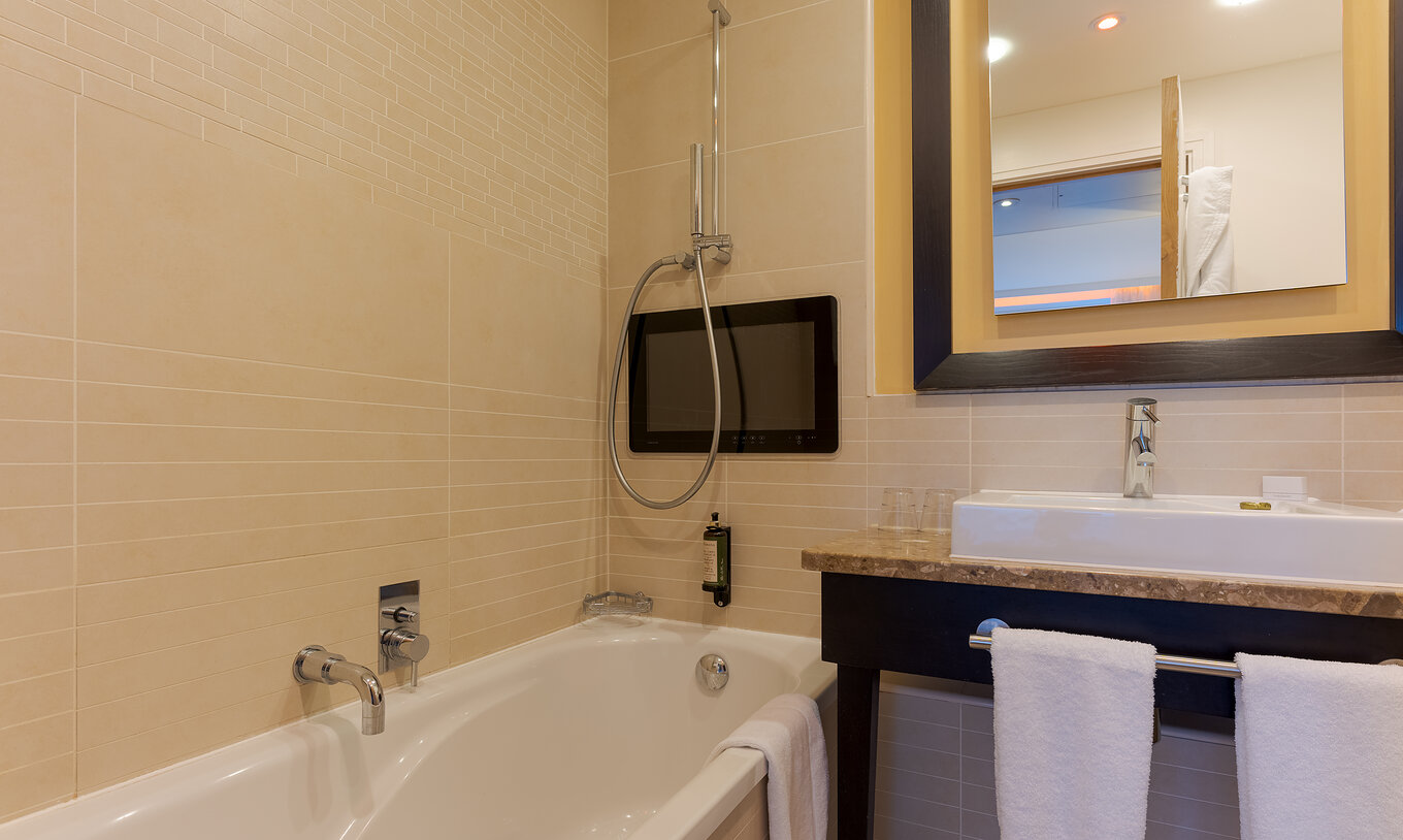 La Executive One Bedroom Suite del Pestana Chelsea Bridge tiene baño con bañera, lavabo, espejos y secador