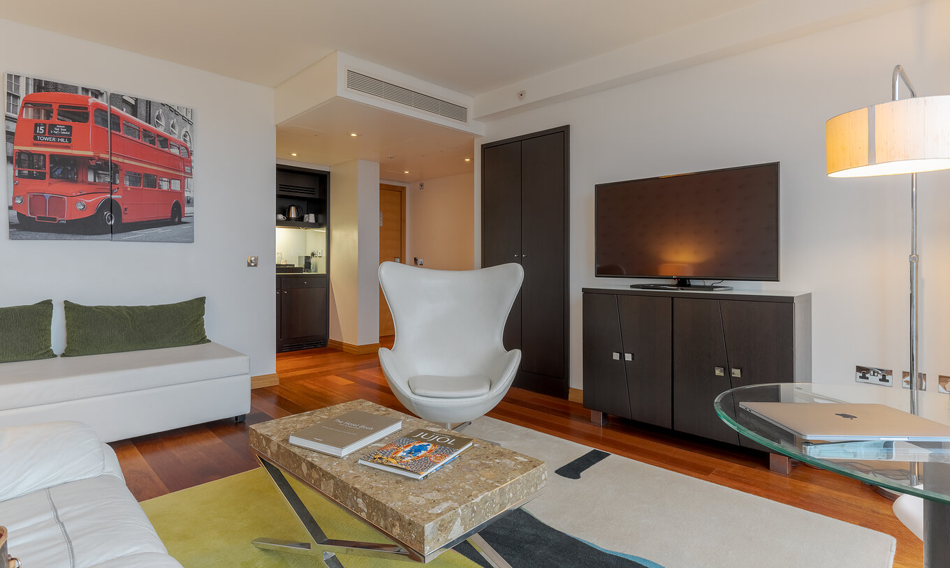 La Executive One Bedroom Suite del Pestana Chelsea Bridge tiene sala con sofá, mesa de centro, sillón y televisor