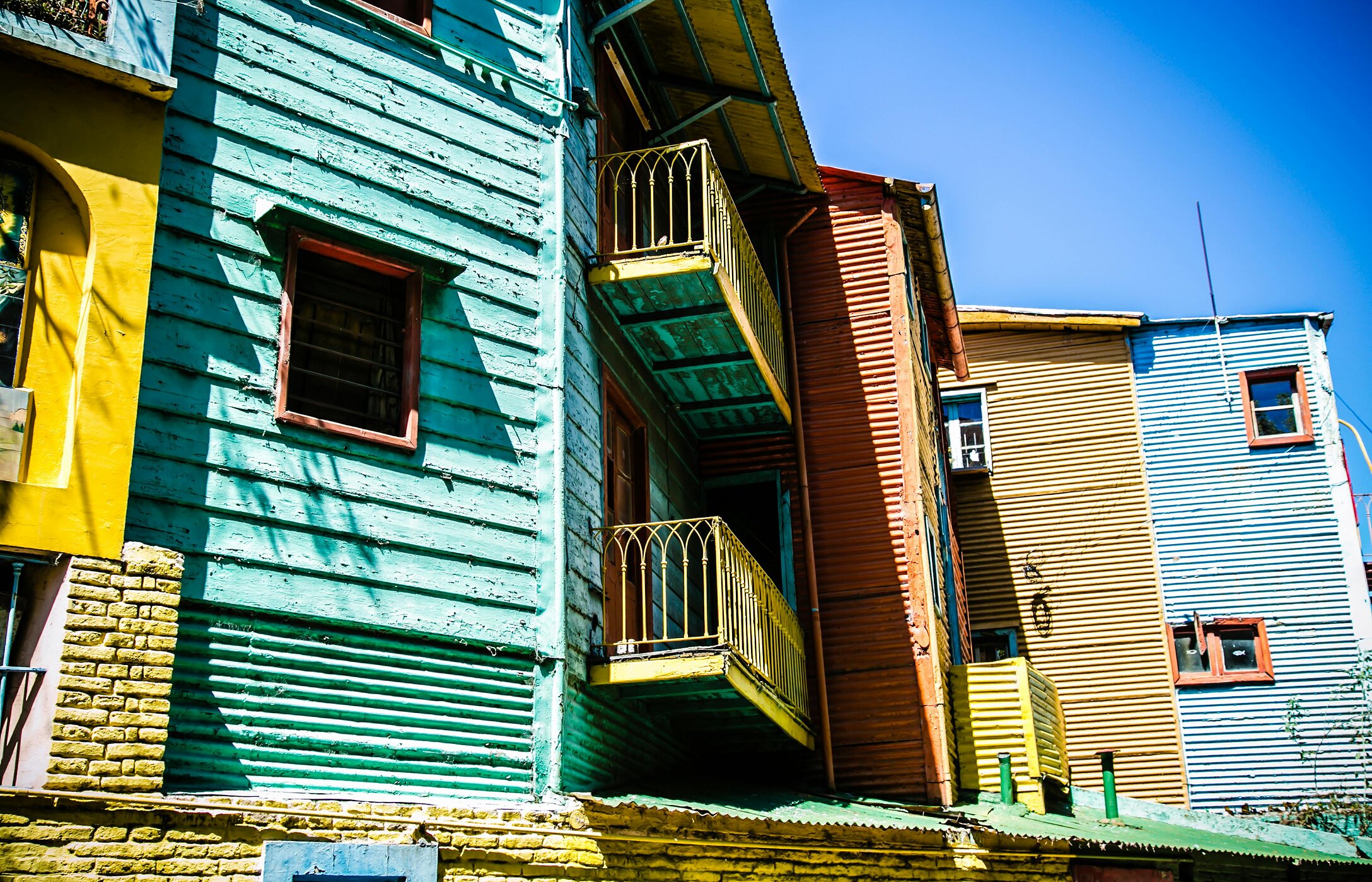 Façades de maisons en bois colorées avec balcons, typiques du quartier Caminito à Buenos Aires, Argentine