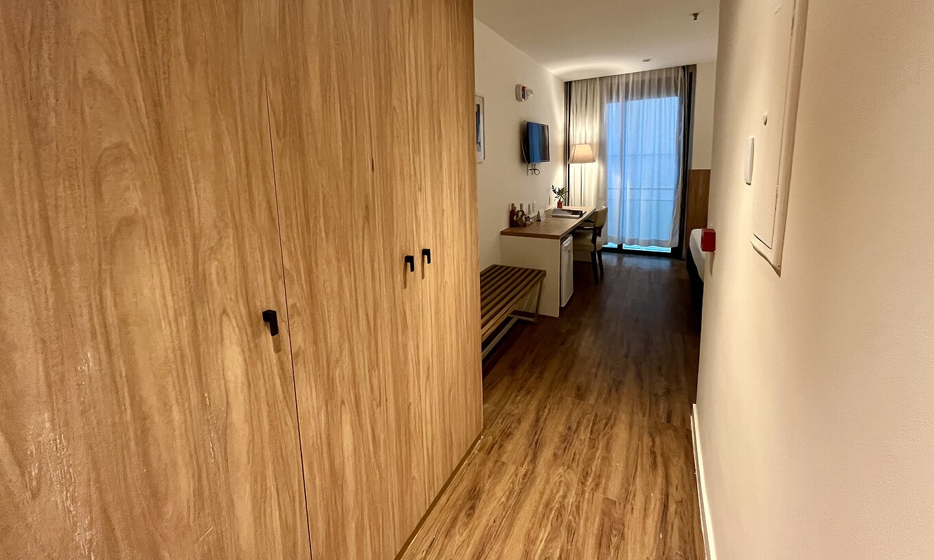 La Chambre Semi-Adaptée du Pestana Rio Atlântica a un couloir avec armoire et bureau près de la fenêtre