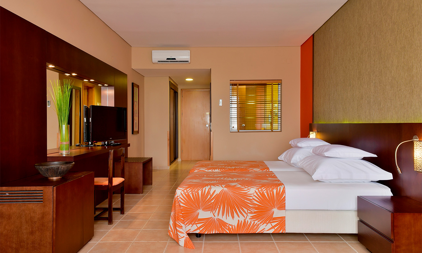 Le Chambre Standard du Pestana Tropico comprend deux lits simples, télévision, table de chevet, miroir et une chaise