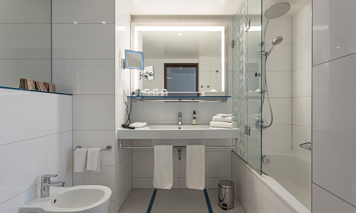 La Chambre Deluxe du Pestana Berlin Tiergarten a une Salle de Bain avec Baignoire et Douche, et un Lavabo