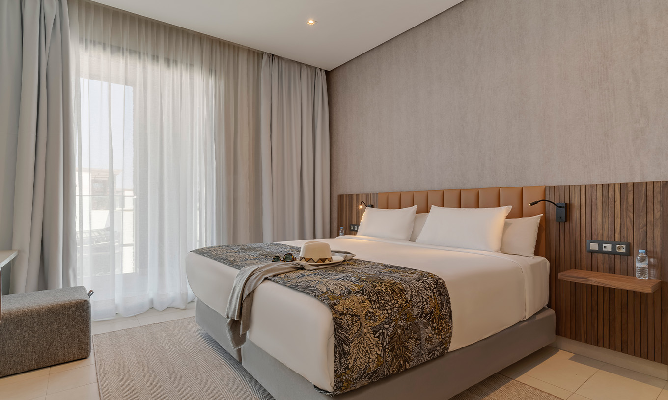 La Suite Familiale Corniche du Pestana Casablanca a une chambre avec un lit double avec une décoration moderne
