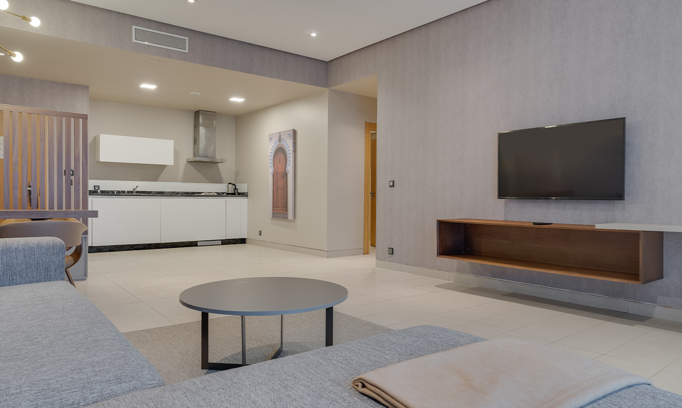 La Suite Familiale du Pestana Casablanca a un salon spacieux avec canapé, tv satellite, une table à manger et une kitchenette