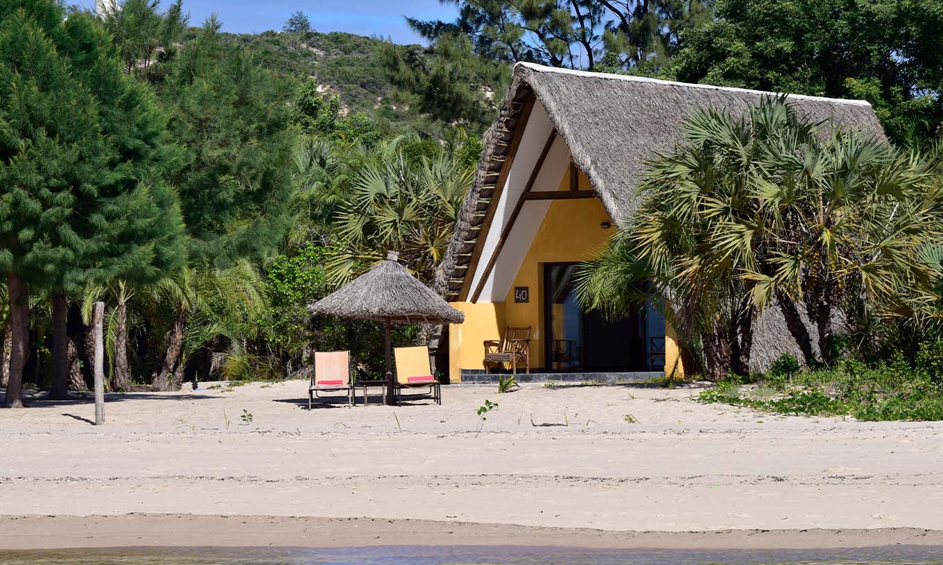 Le Bungalow Suite T2 du Pestana Bazaruto Lodge est une maison avec toit de chaume sur la plage et immergée dans la nature