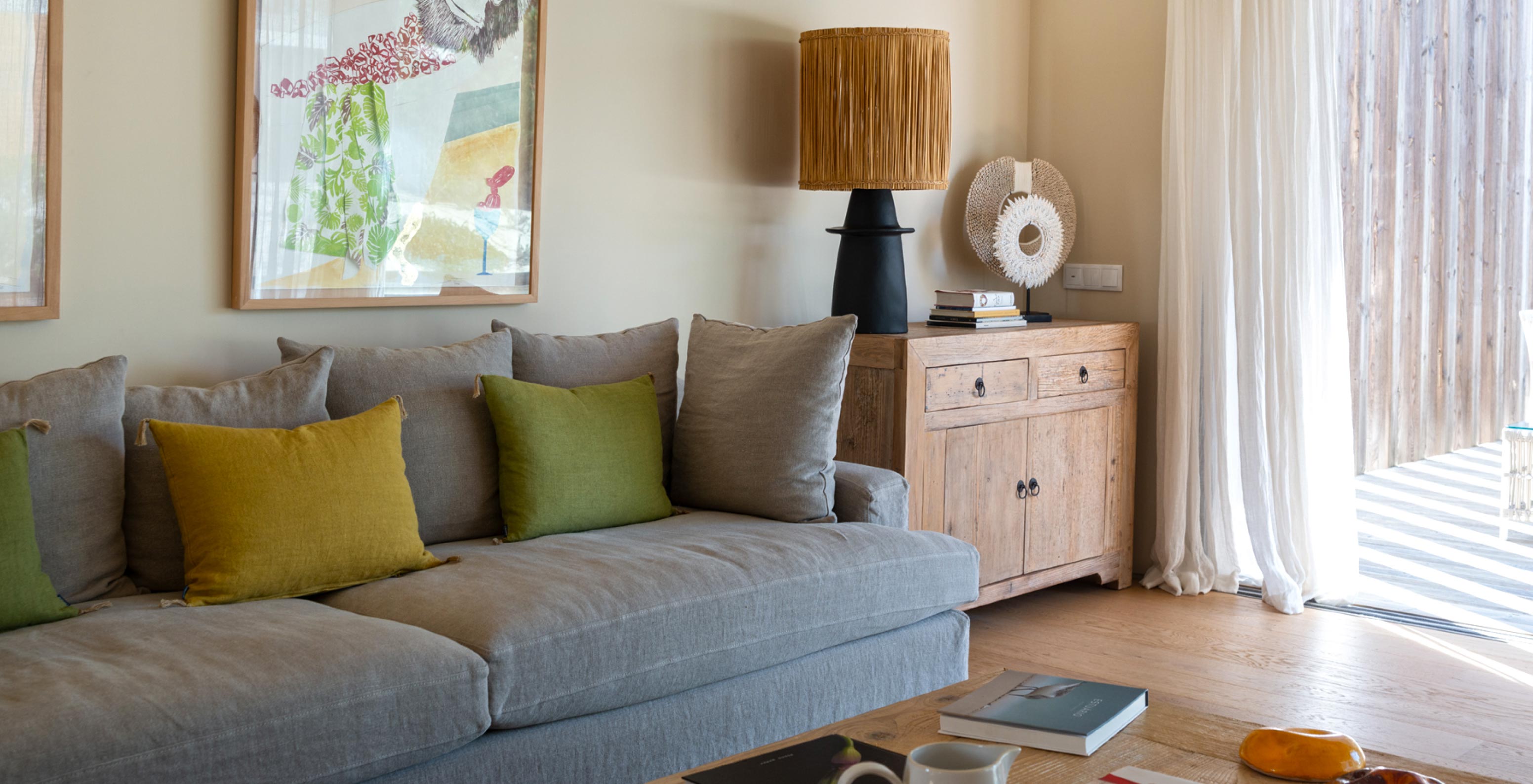 La villa exclusive avec piscine du Pestana Tróia Eco Resort a un salon avec canapé gris et grande fenêtre avec rideaux