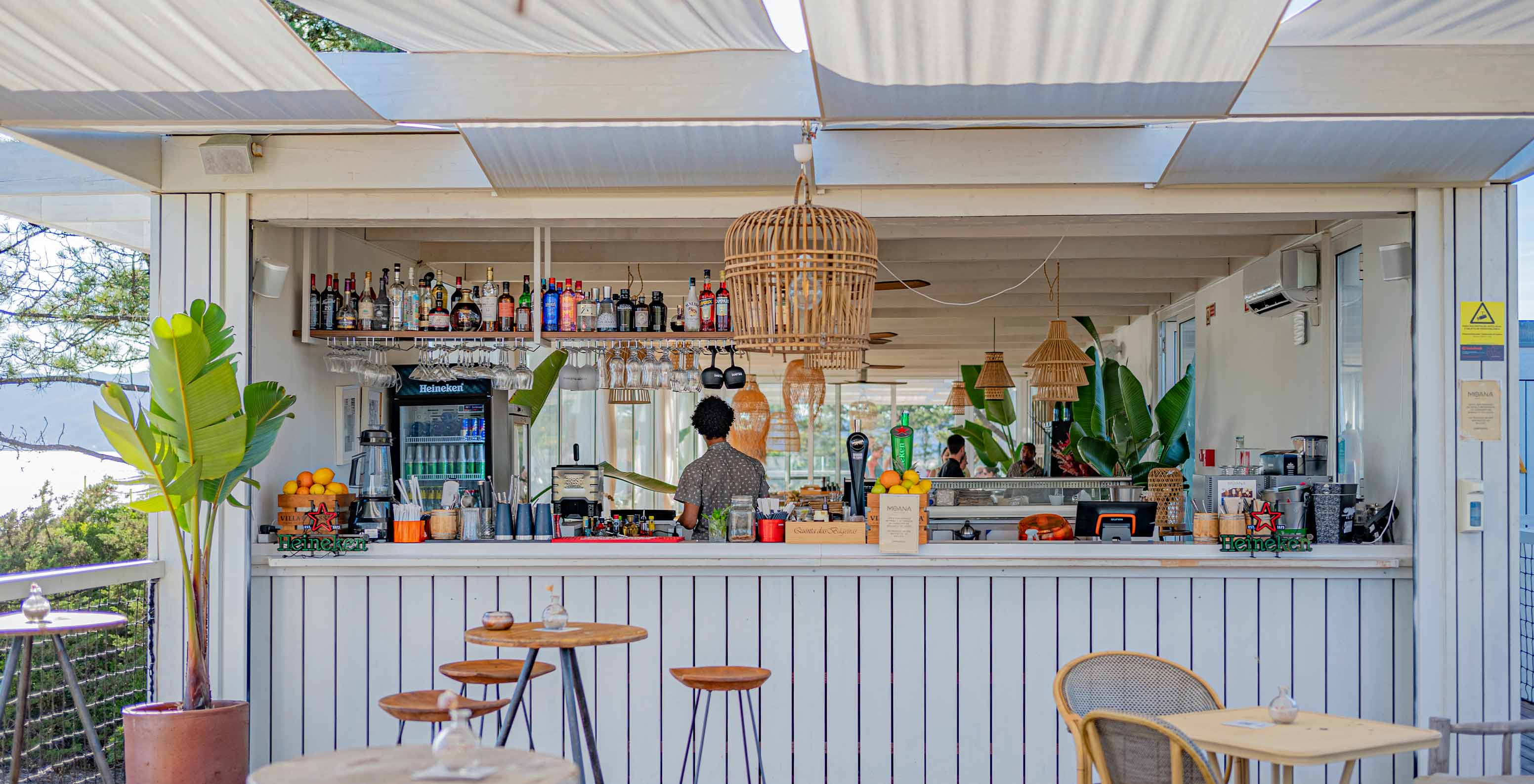 Le bar Moana Beach Club du Pestana Tróia Eco Resort a tables en bois, chaises et comptoir à boissons