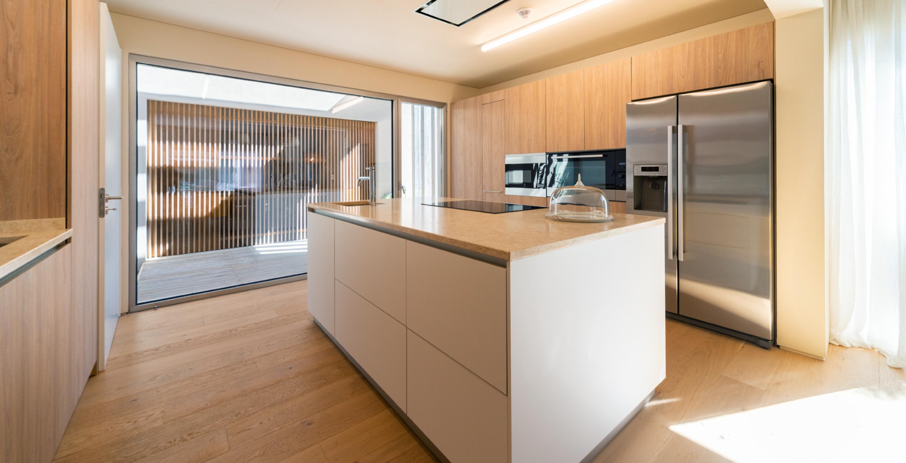 La villa exclusive avec piscine du Pestana Tróia Eco Resort a une cuisine équipée, des armoires en bois et un îlot central