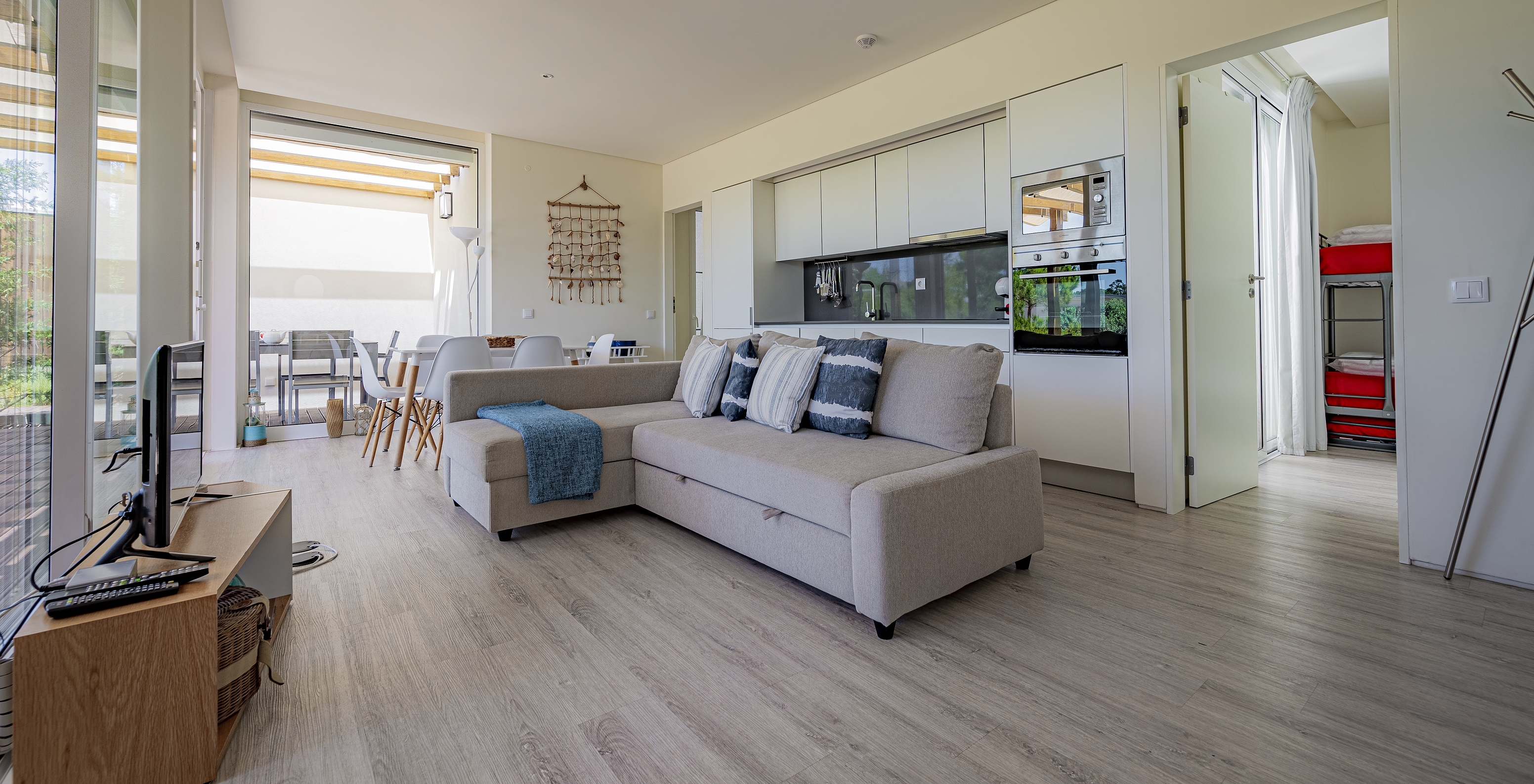 La Green Villa du Pestana Tróia Eco Resort a une salle combinée à la cuisine avec canapé, table à manger et télévision