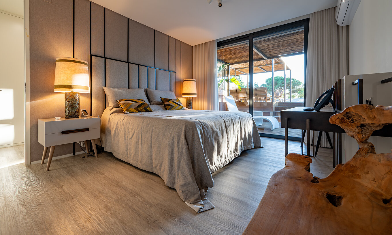 Les Deluxe Villas avec piscine privée du Pestana Tróia Eco Resort ont un lit double avec accès à la terrasse