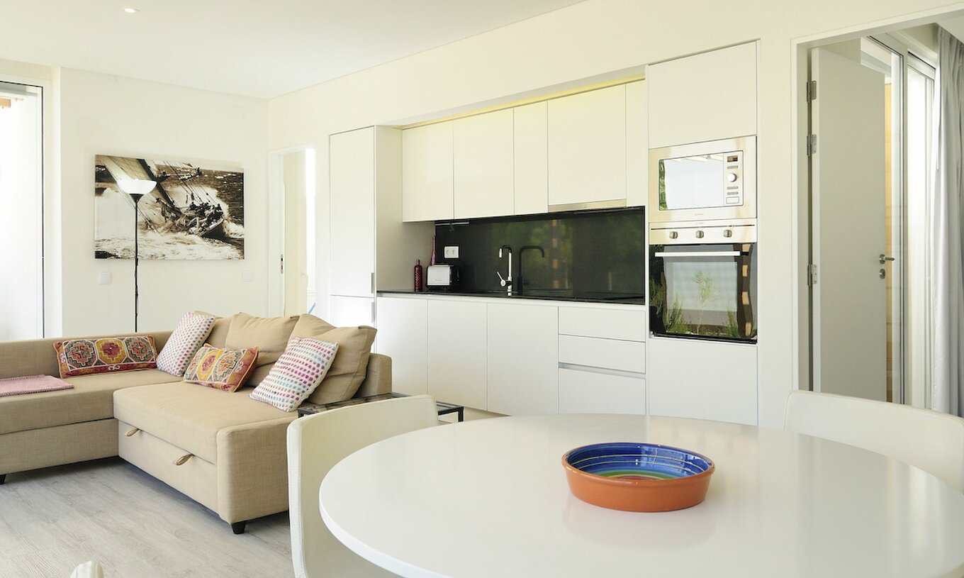 La Green Villa avec piscine privée T3 du Pestana Tróia Eco Resort a une salle combinée à la cuisine, canapé et table à manger