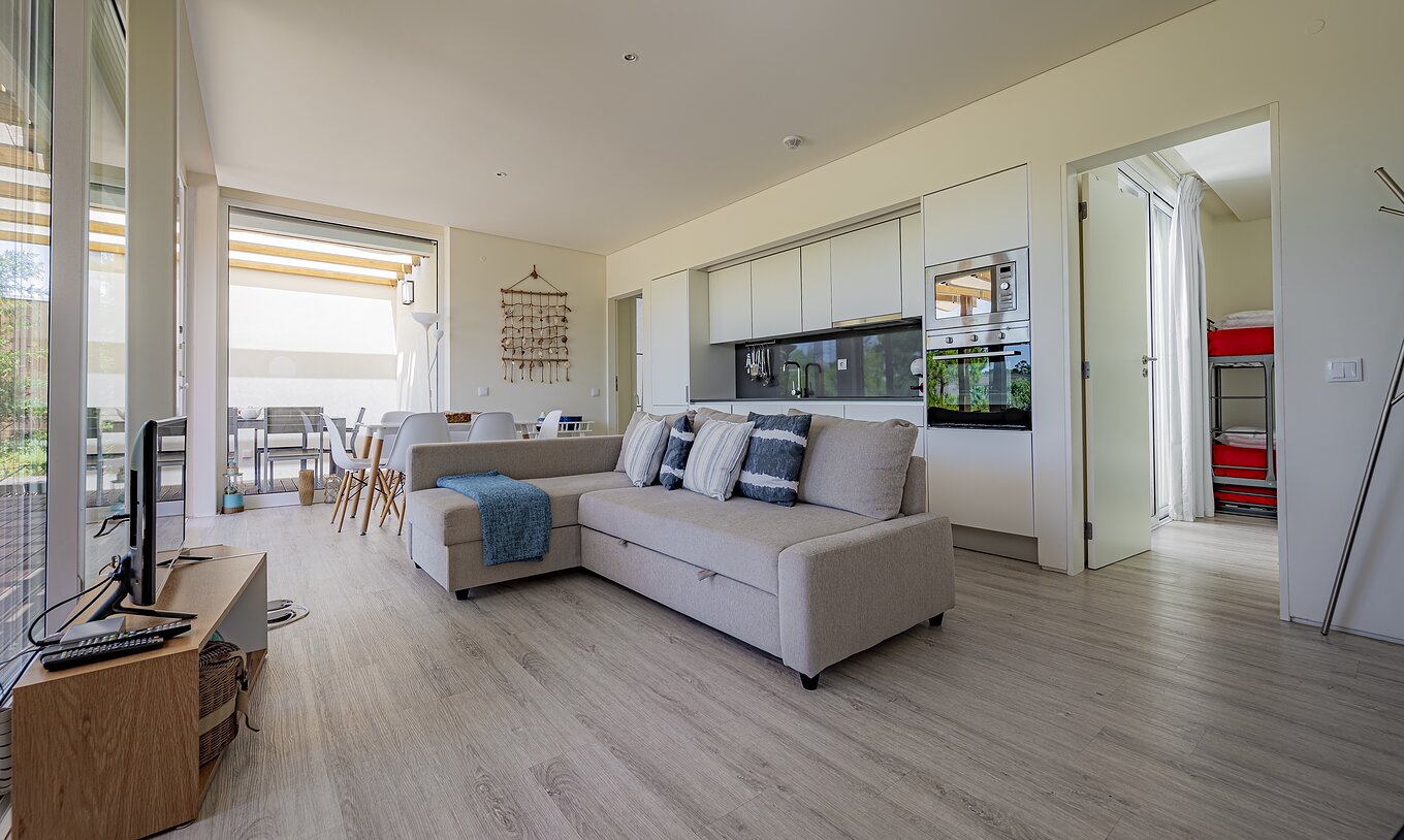 La Green Villa du Pestana Tróia Eco Resort a une salle combinée à la cuisine avec canapé, table à manger et télévision