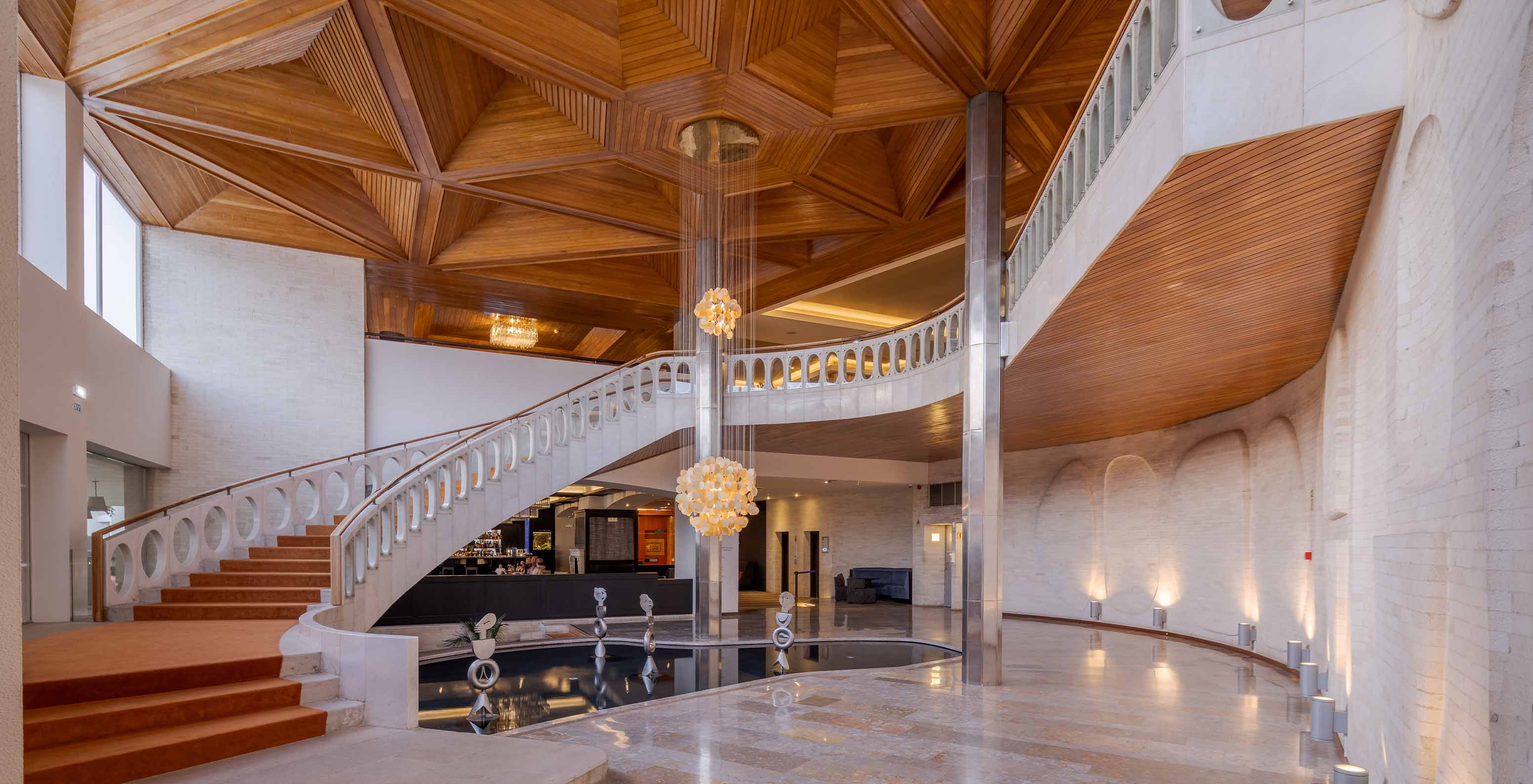 Escalier en tons clairs avec tapis orange dans le hall du Pestana Alvor Praia, hôtel avec spa, piscine et accès à la plage