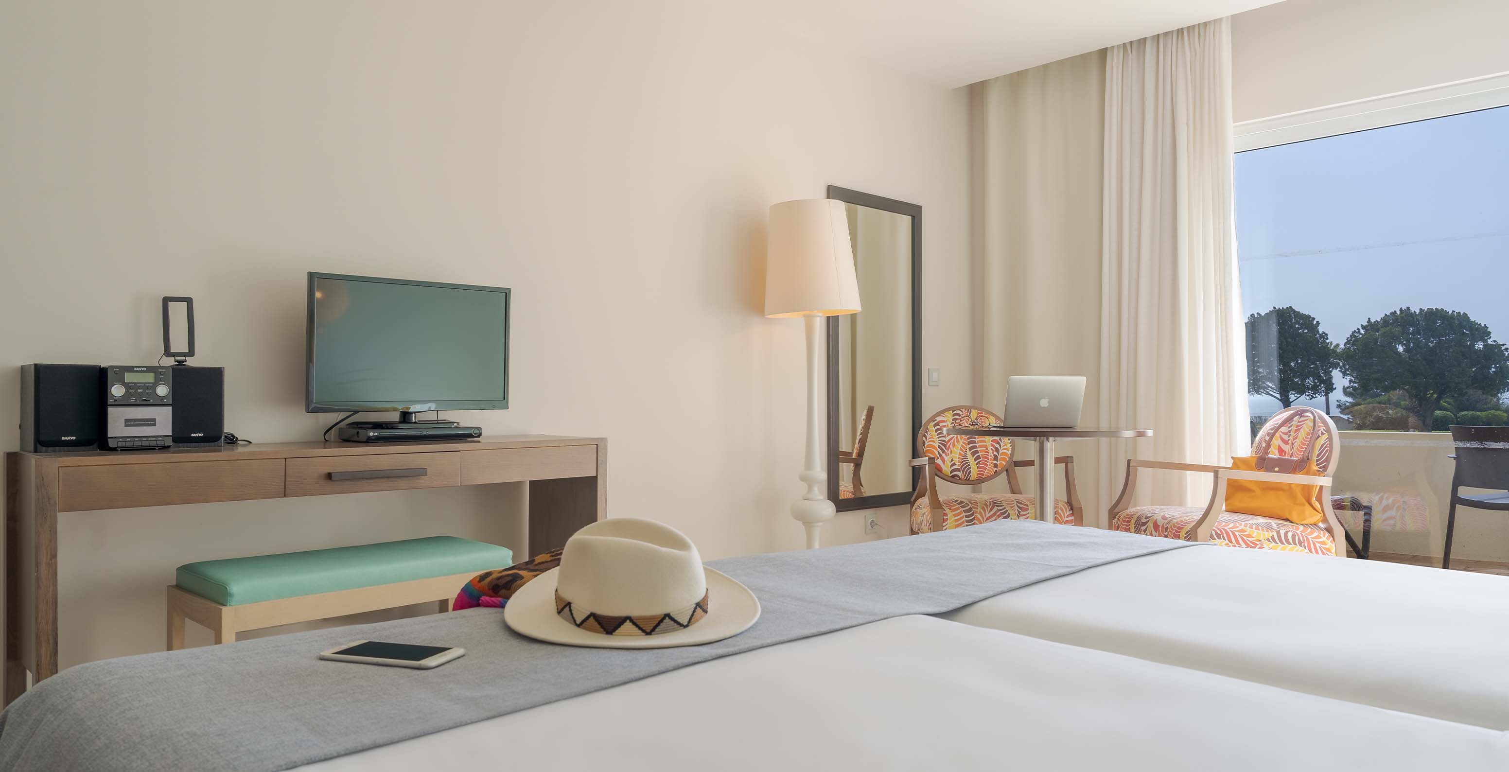 Le Studio Vue Mer du Pestana Alvor Praia a un bureau avec télévision, miroir mural et fenêtre avec accès au balcon