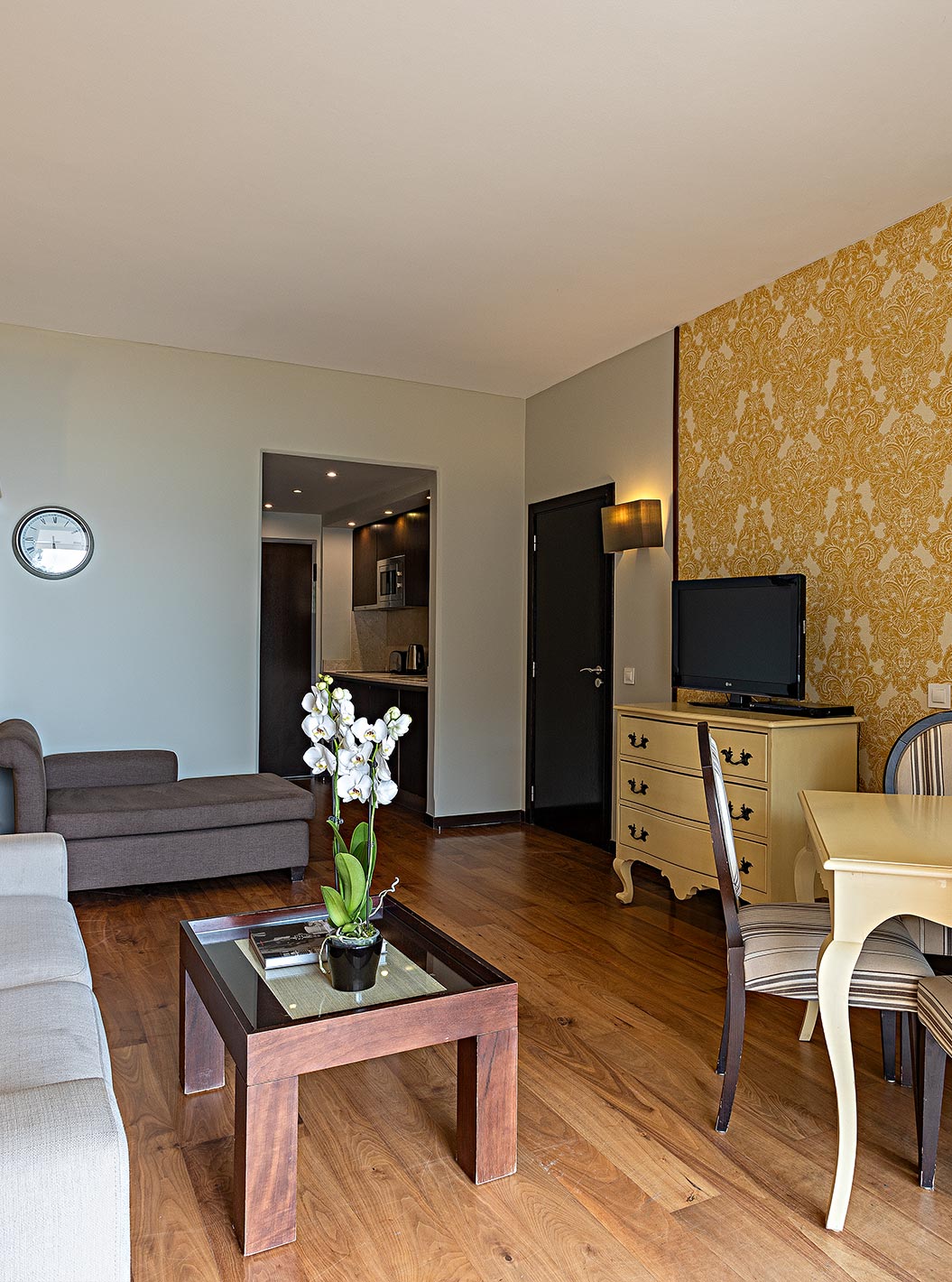 La suite Cliff T1 du Pestana Alvor Praia a un salon avec TV et un balcon avec table, chaises et vue sur la mer