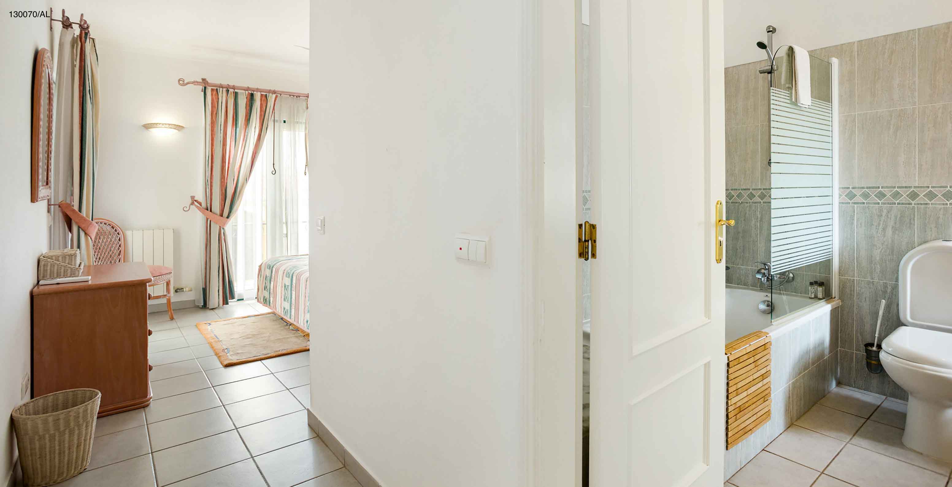 L'appartement Pestana Carvoeiro Golf T2 Superior dispose d'une chambre avec salle de bain et une commode en bois