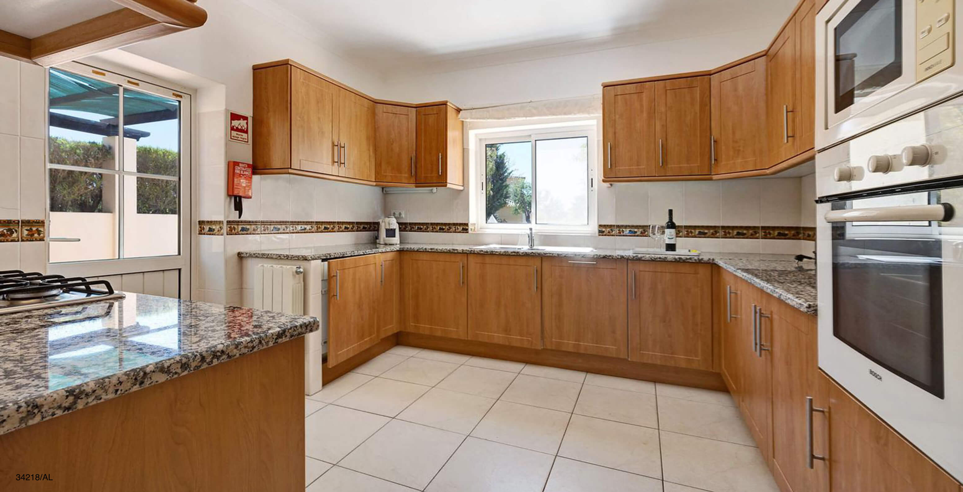 La villa Pestana Carvoeiro Golf V4 Standard dispose d'une cuisine avec des armoires en bois et des appareils