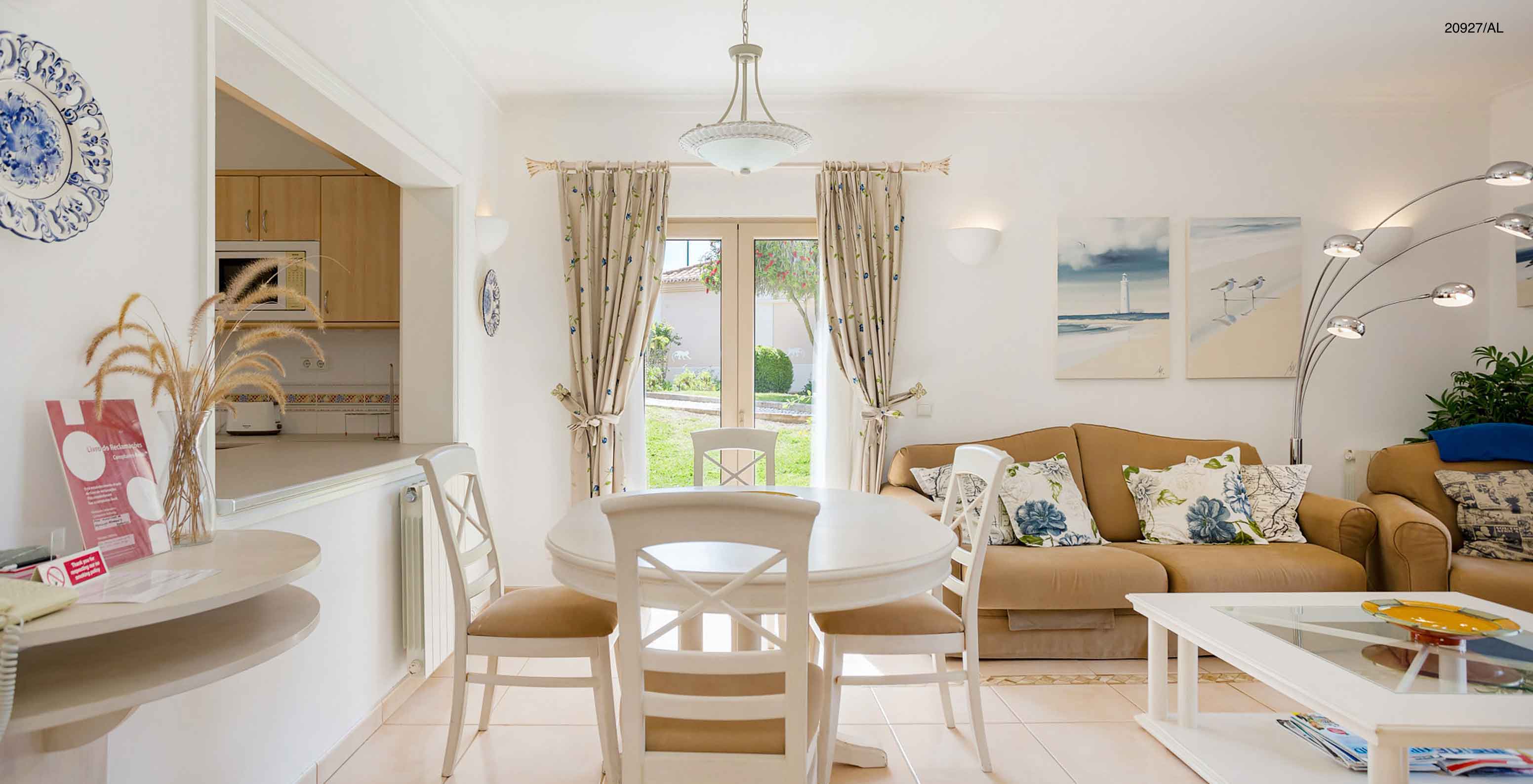 L'appartement Pestana Carvoeiro Golf T2 Superior dispose d'une salle à manger avec une table ronde, des chaises et un canapé