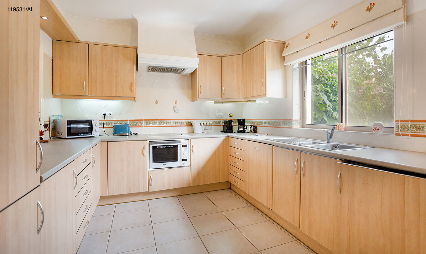 L'appartement Pestana Carvoeiro Golf T1 Standard dispose d'une cuisine avec des armoires en bois et des appareils