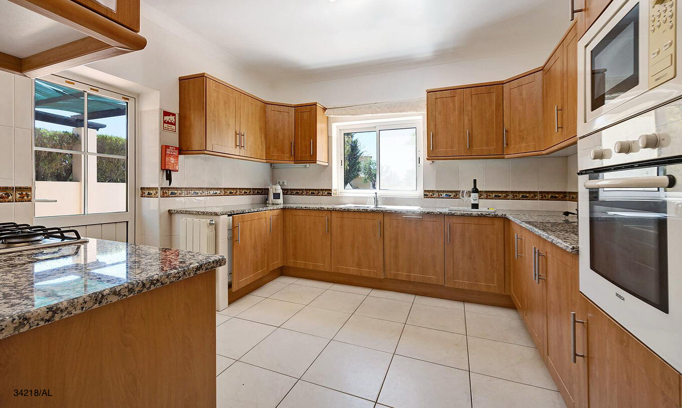 La villa Pestana Carvoeiro Golf V4 Standard dispose d'une cuisine avec des armoires en bois et des appareils