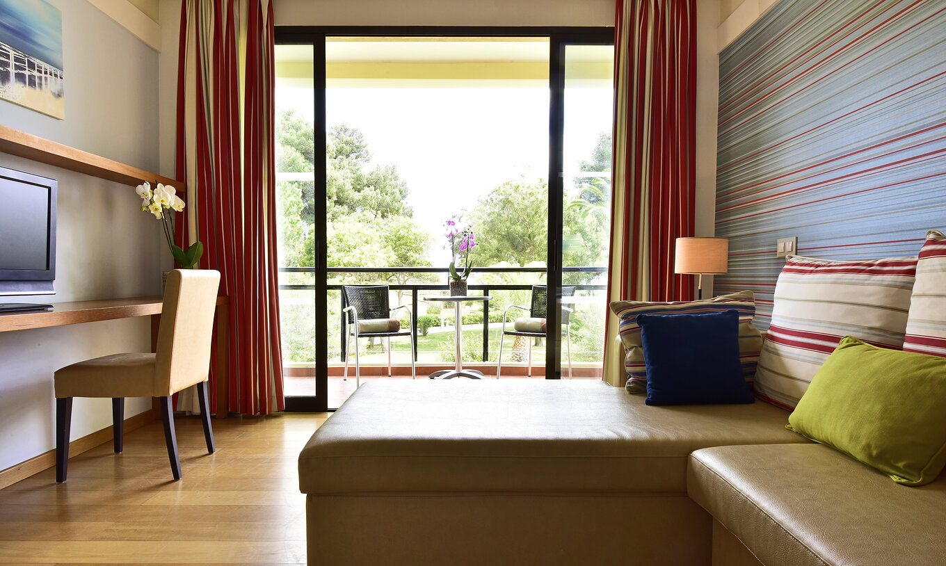 La Suite Standard du Pestana Dom João II a un balcon avec vue sur le jardin, un canapé avec chaise longue et télévision