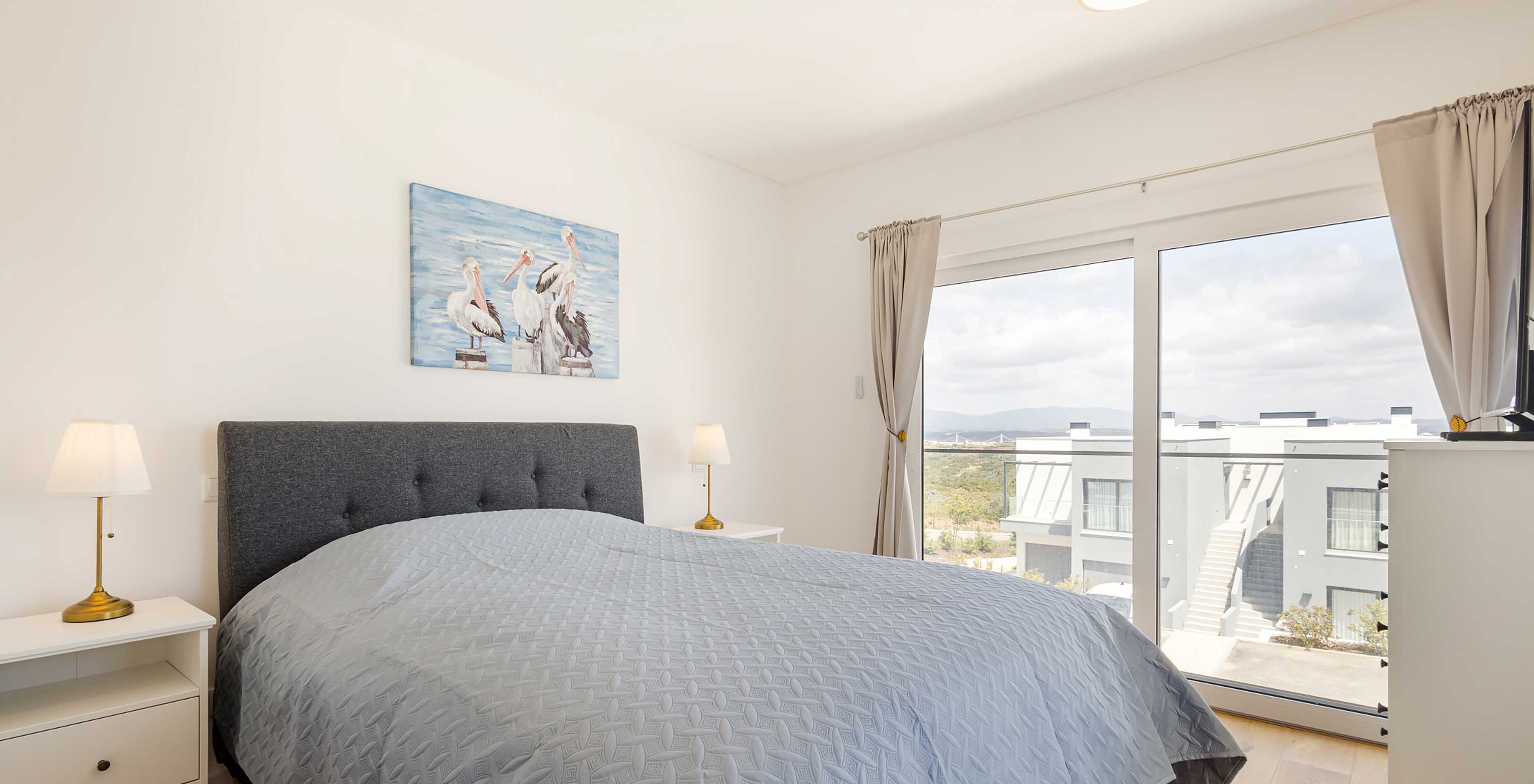 Appartement au Pestana Valley Nature Village avec un lit et des rideaux aux tons gris